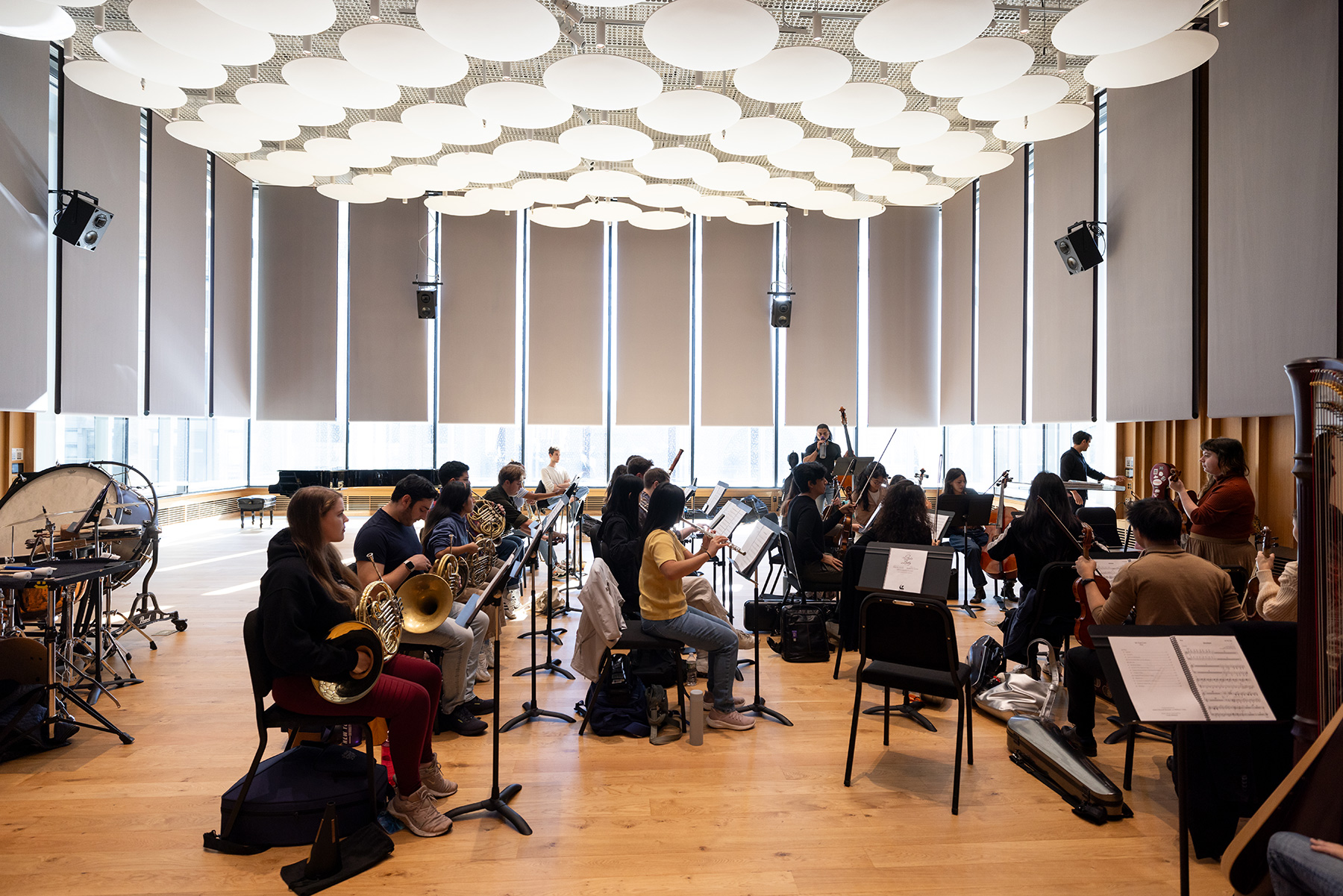 A wide view of an orchestral class practicing their instruments.