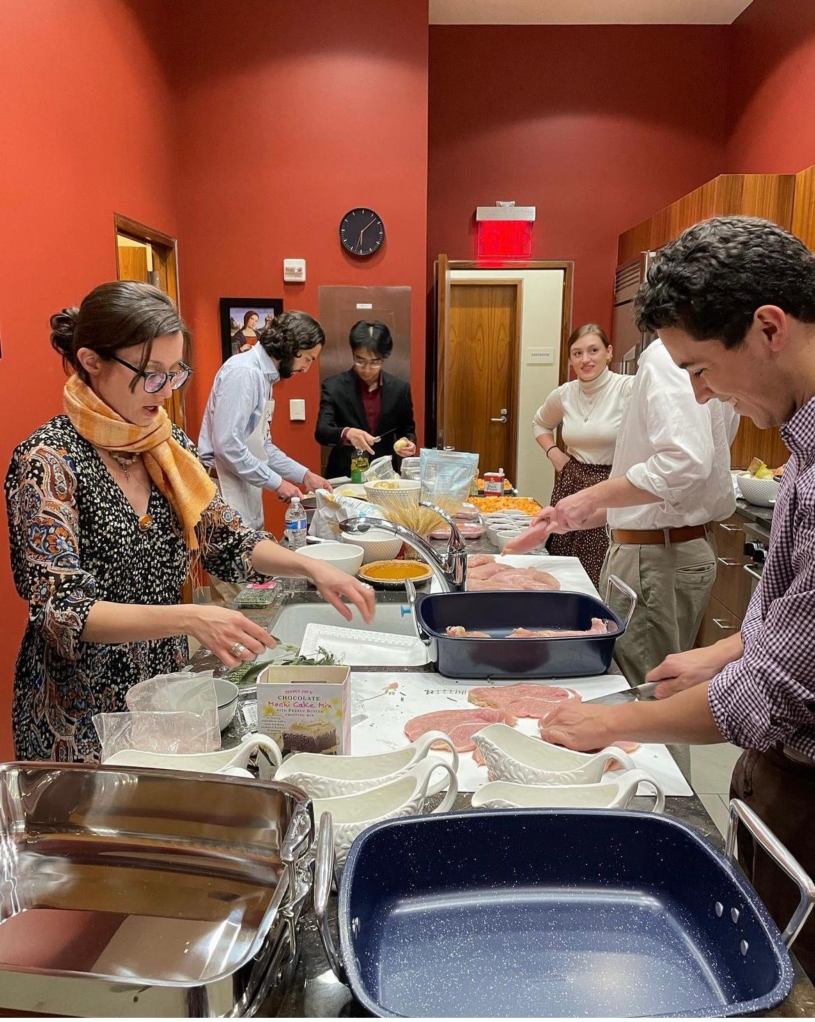 Students serve themselves food from dishes spread on a banquet table in the Catholic Center.