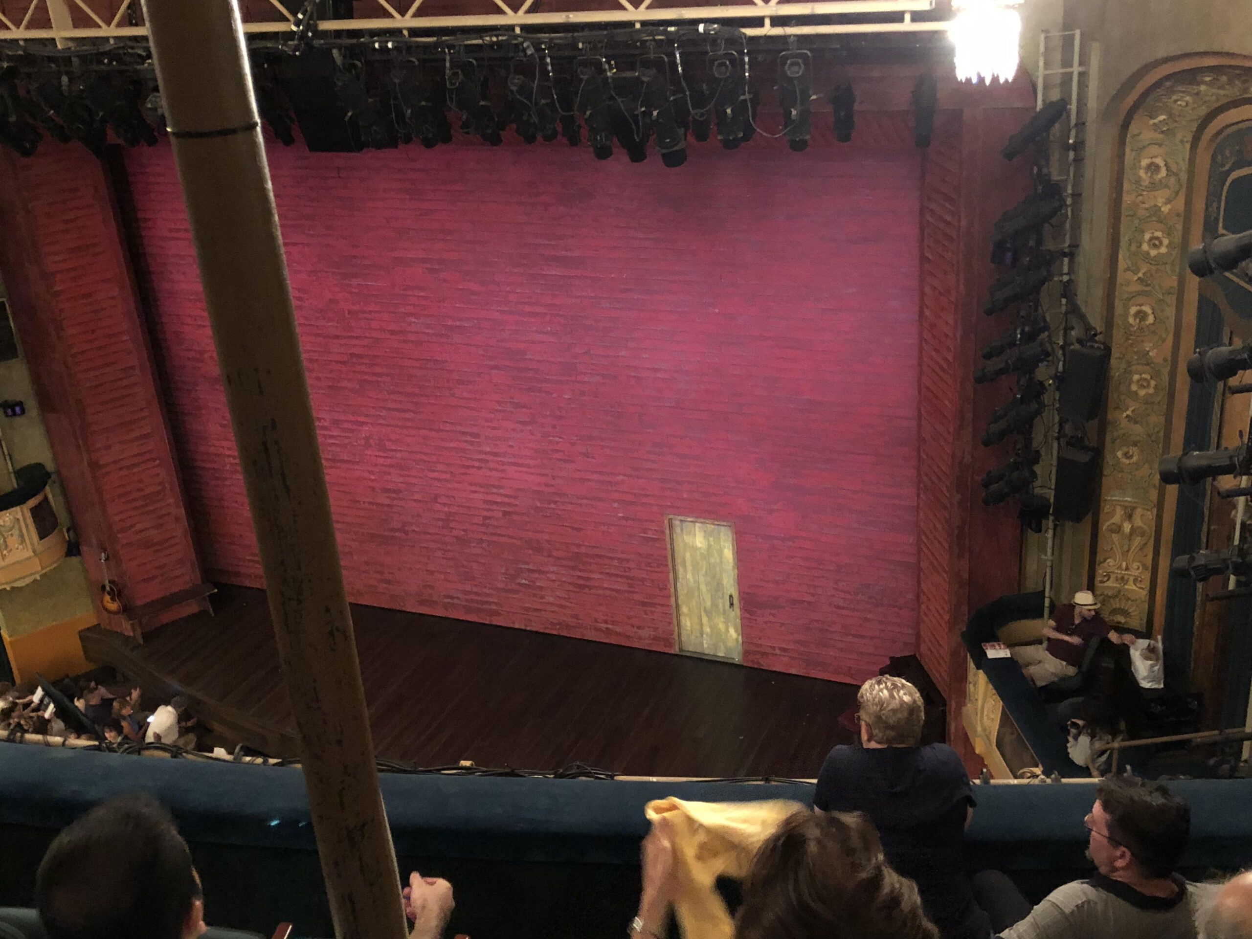 A curtain in the style of a red brick wall on a broadway stage.