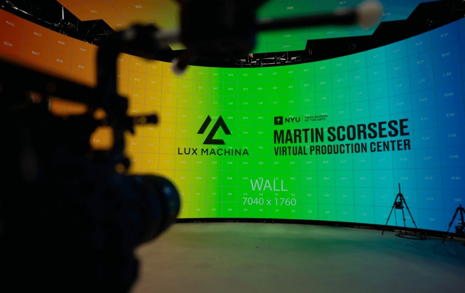 A camera pointing towards a large LED screen displaying the text 