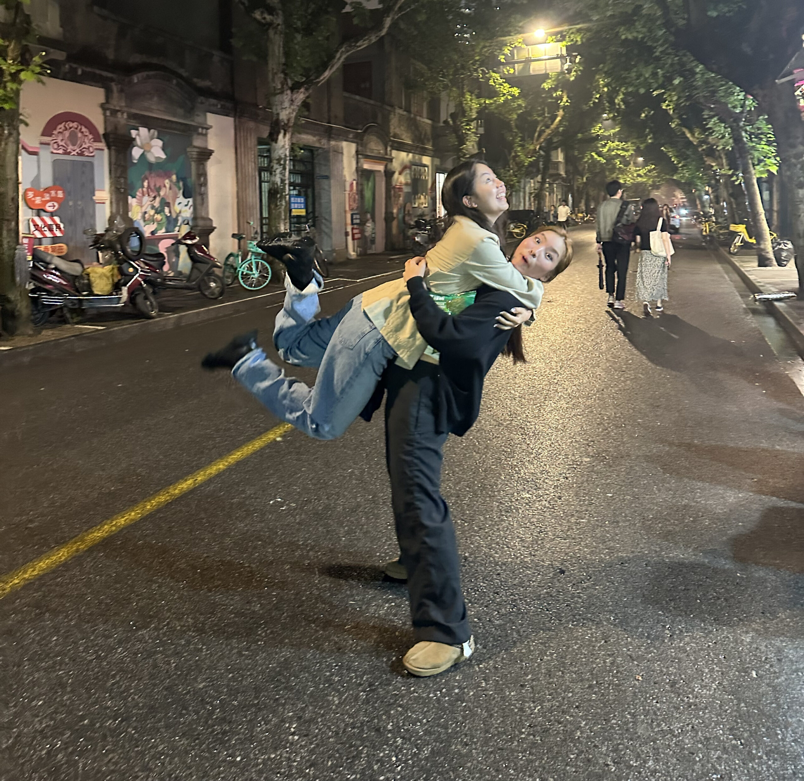 Angela Hong and Kathy Lin hugging in the street