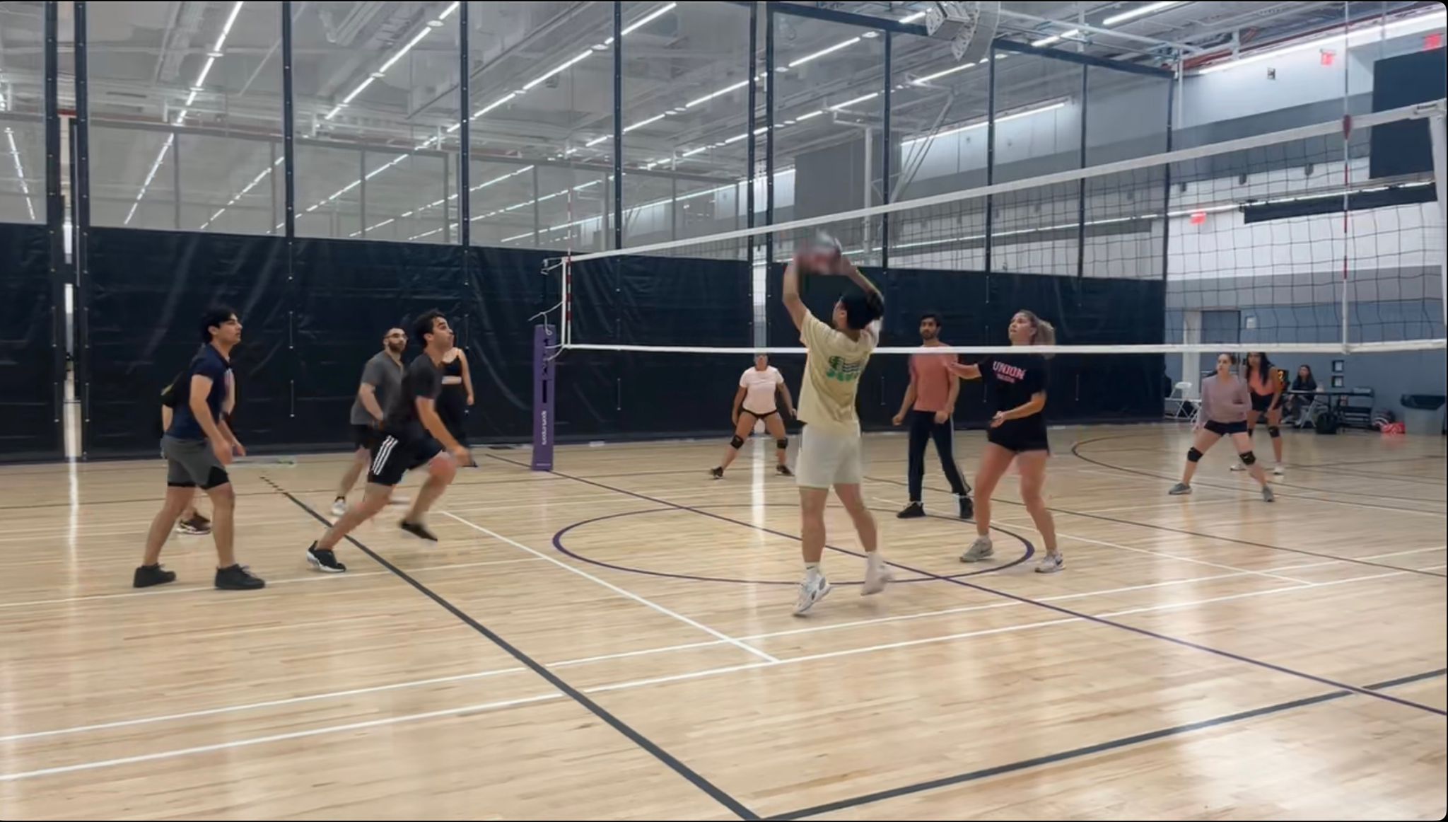 Students play volleyball on a court.