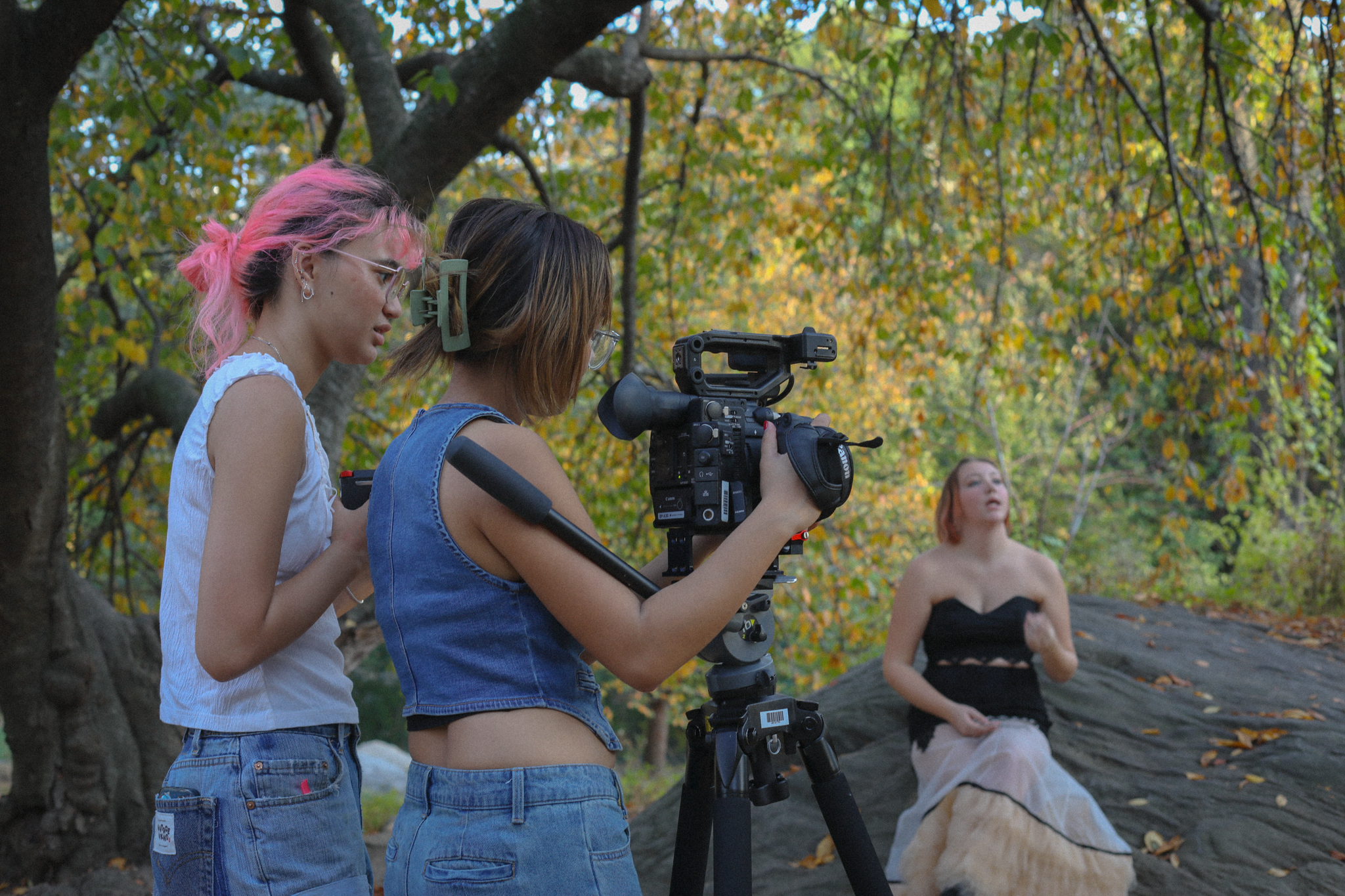 Two girls behind the camera filming an actress in Central Park for an NYU Student Project