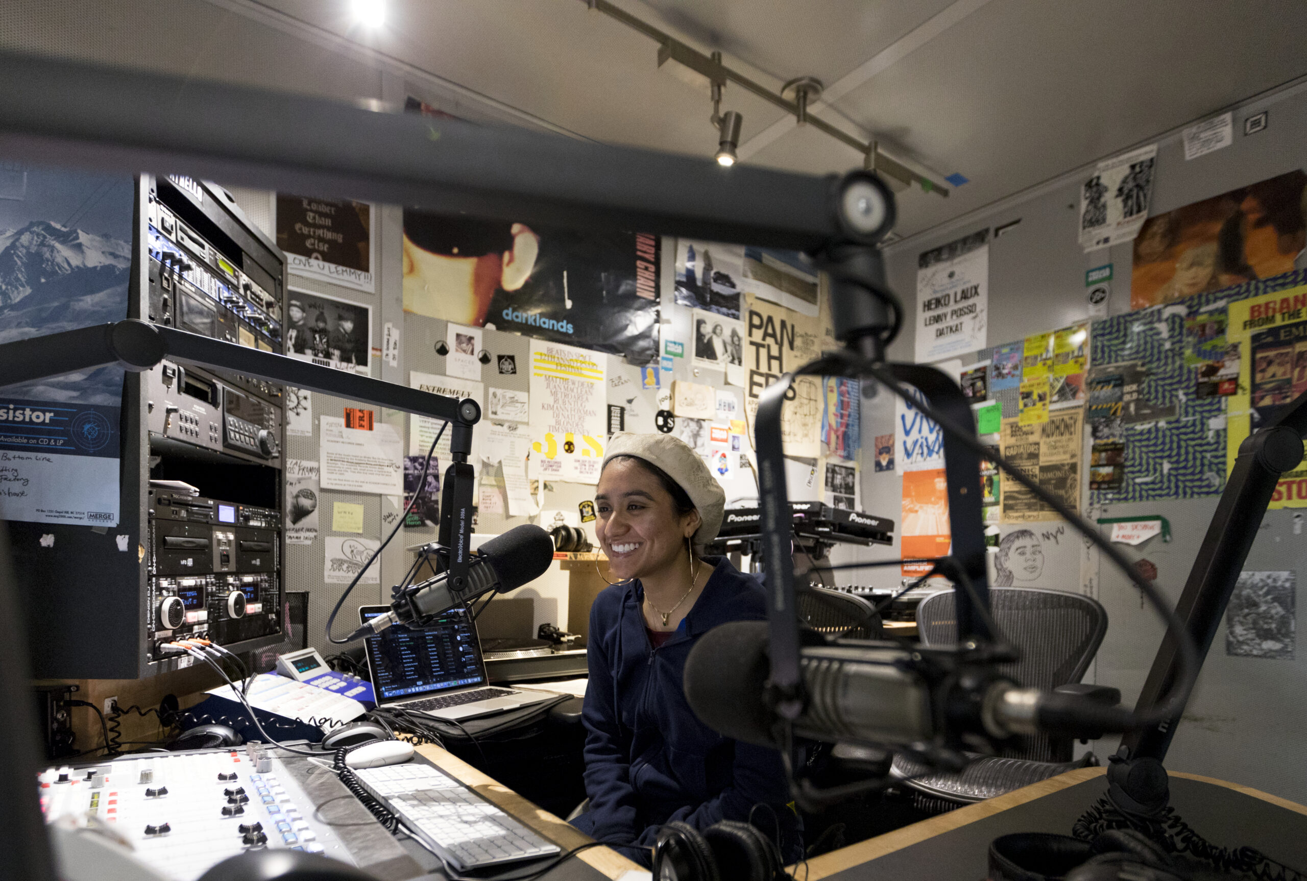 A student talking into a microphone at the NYU radio station WNYU.