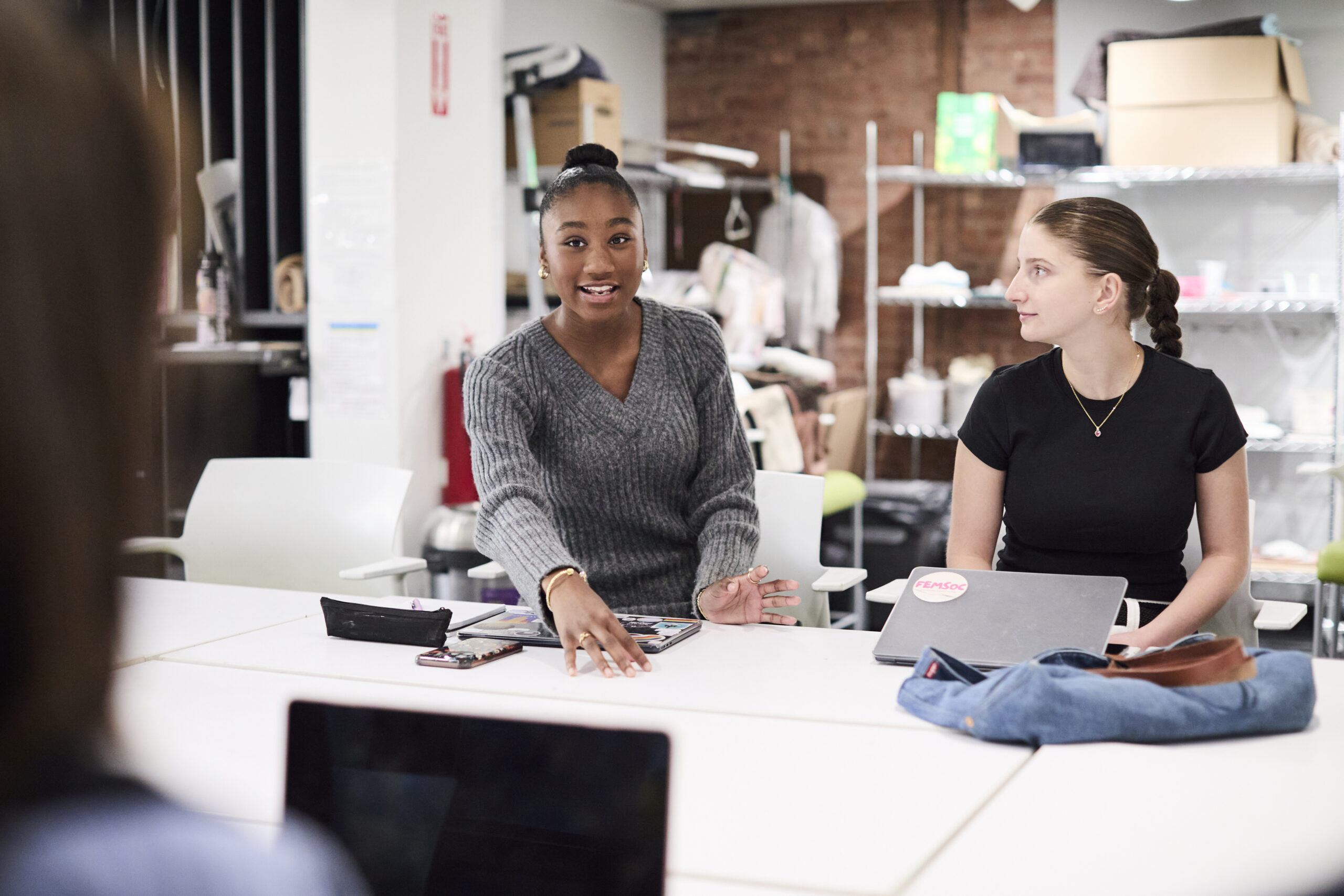 A group of students having a conversation around a table.