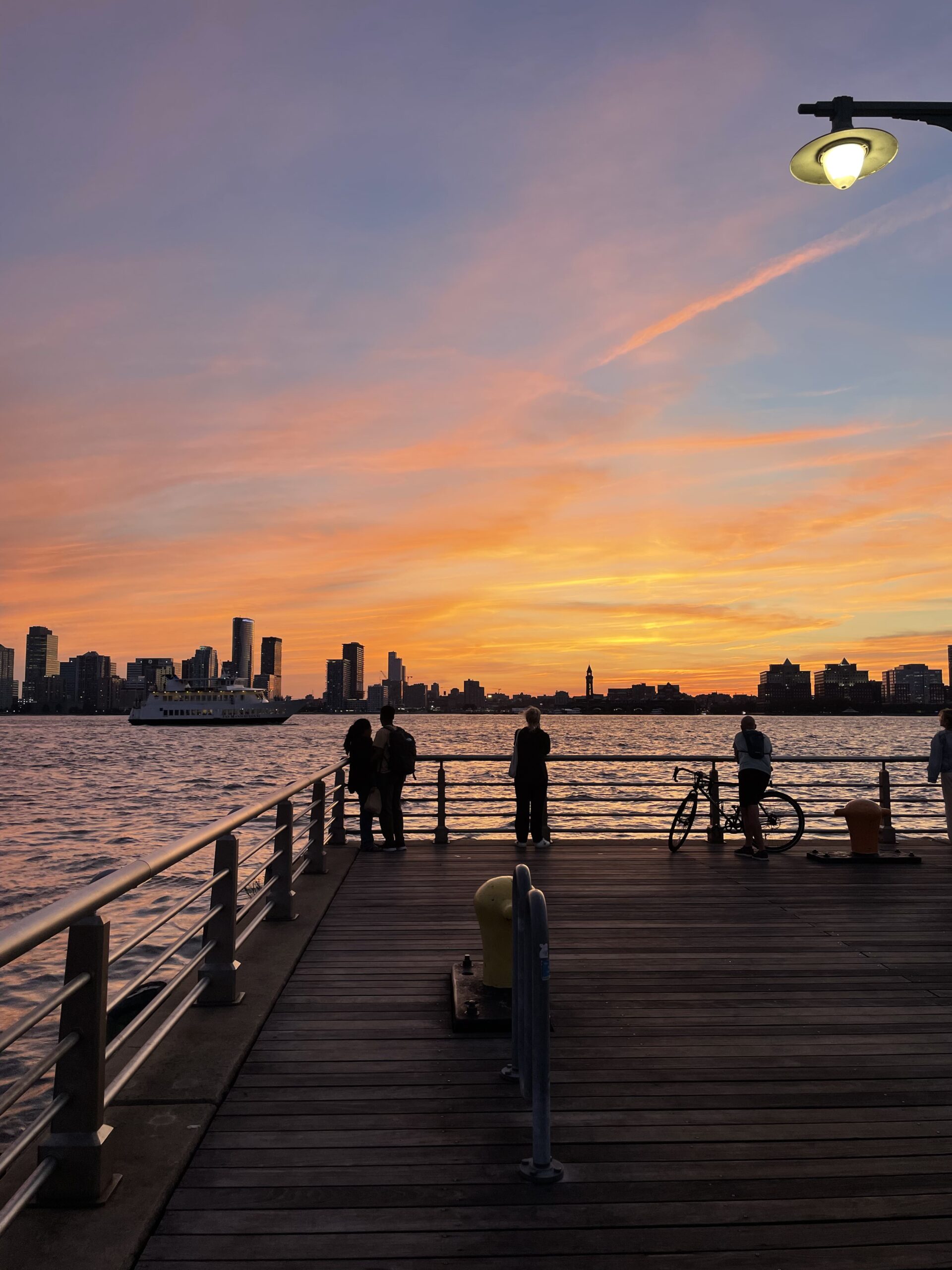 image of a sunset with a pier and some people
