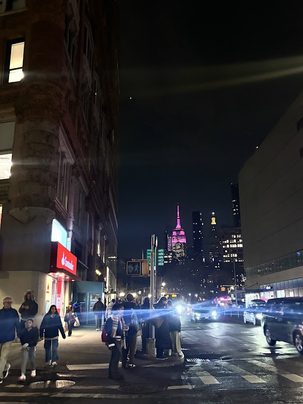 NYC's Broadway near Union Square with bright city lights and a view of the Empire State Building colored pink