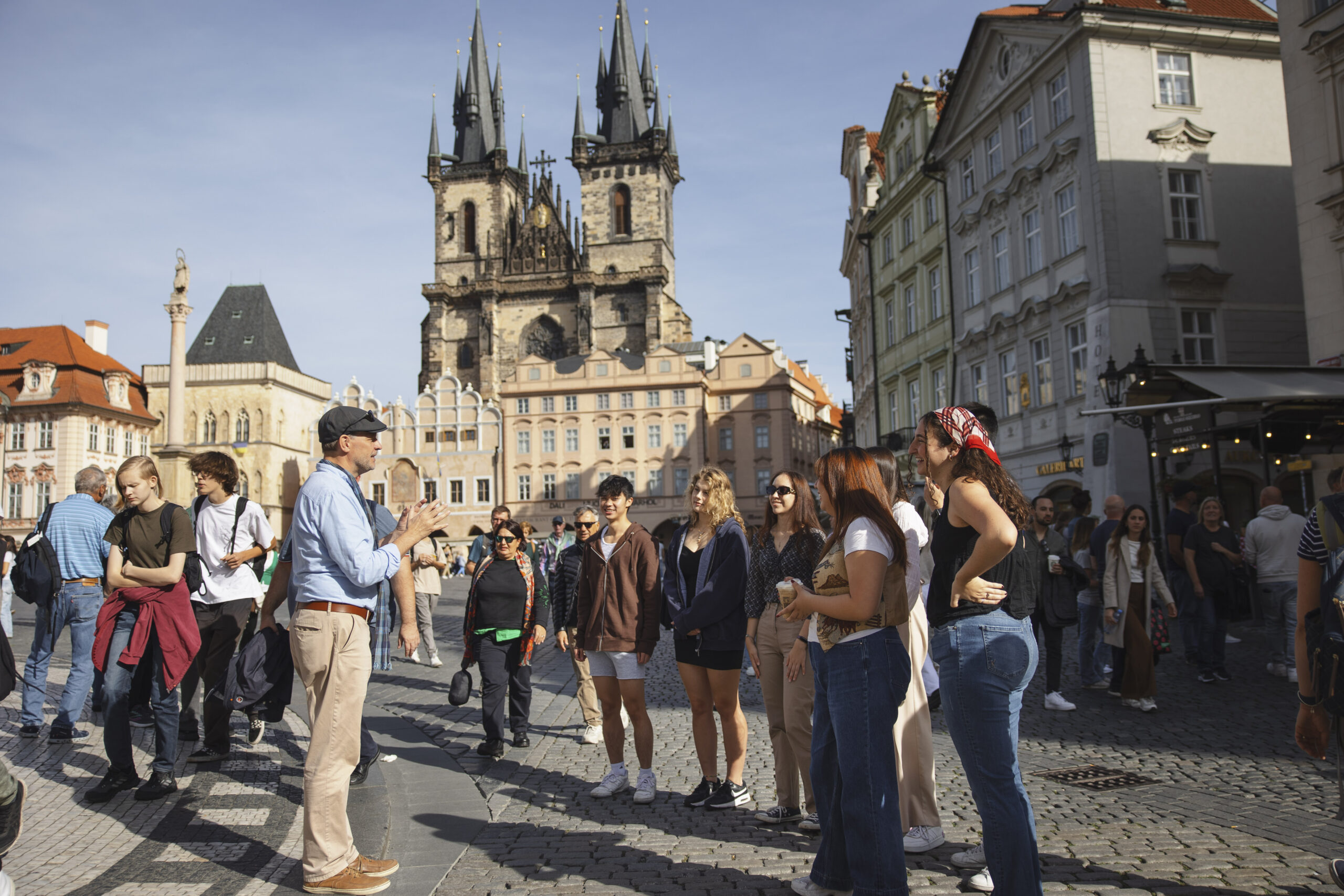 A group of students standing in a sunny plaza in Prague.