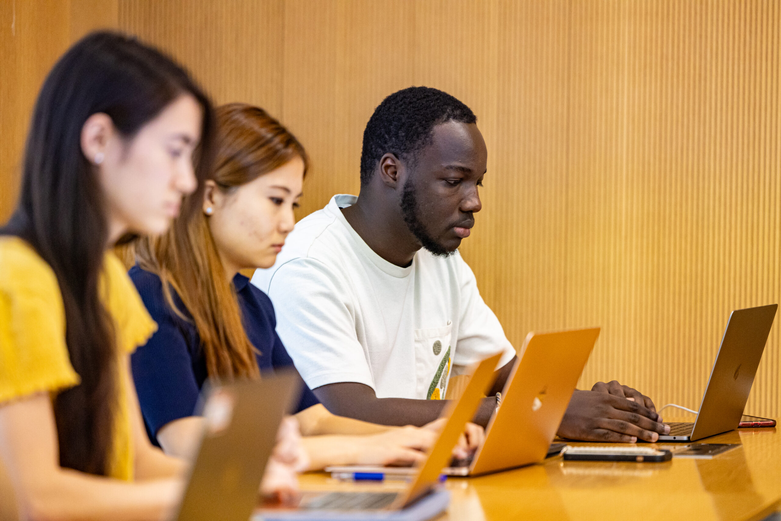 A group of students work on their laptops.