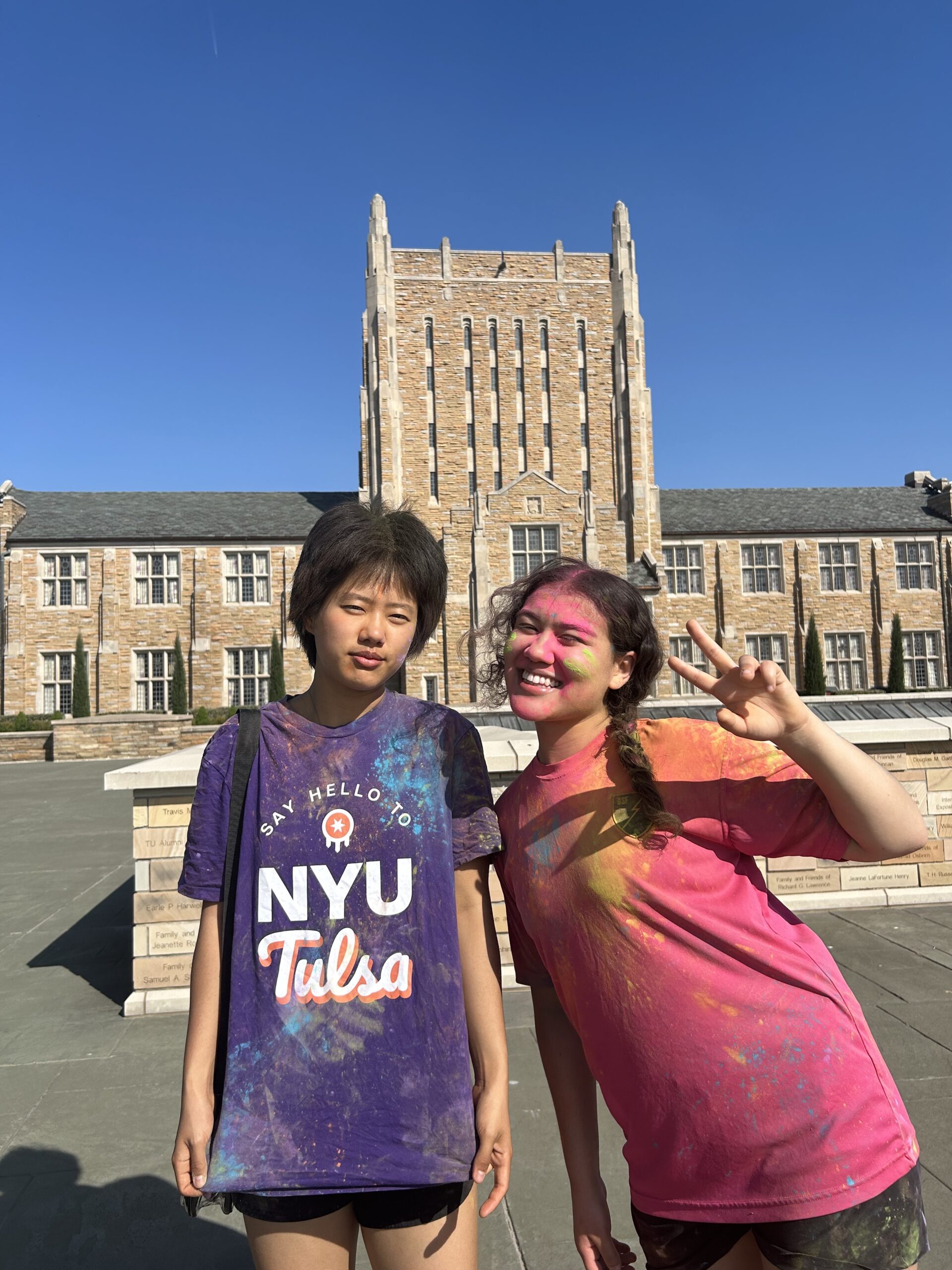 Chok Palmo posing with a friend in an NYU Tulsa T-shirt.