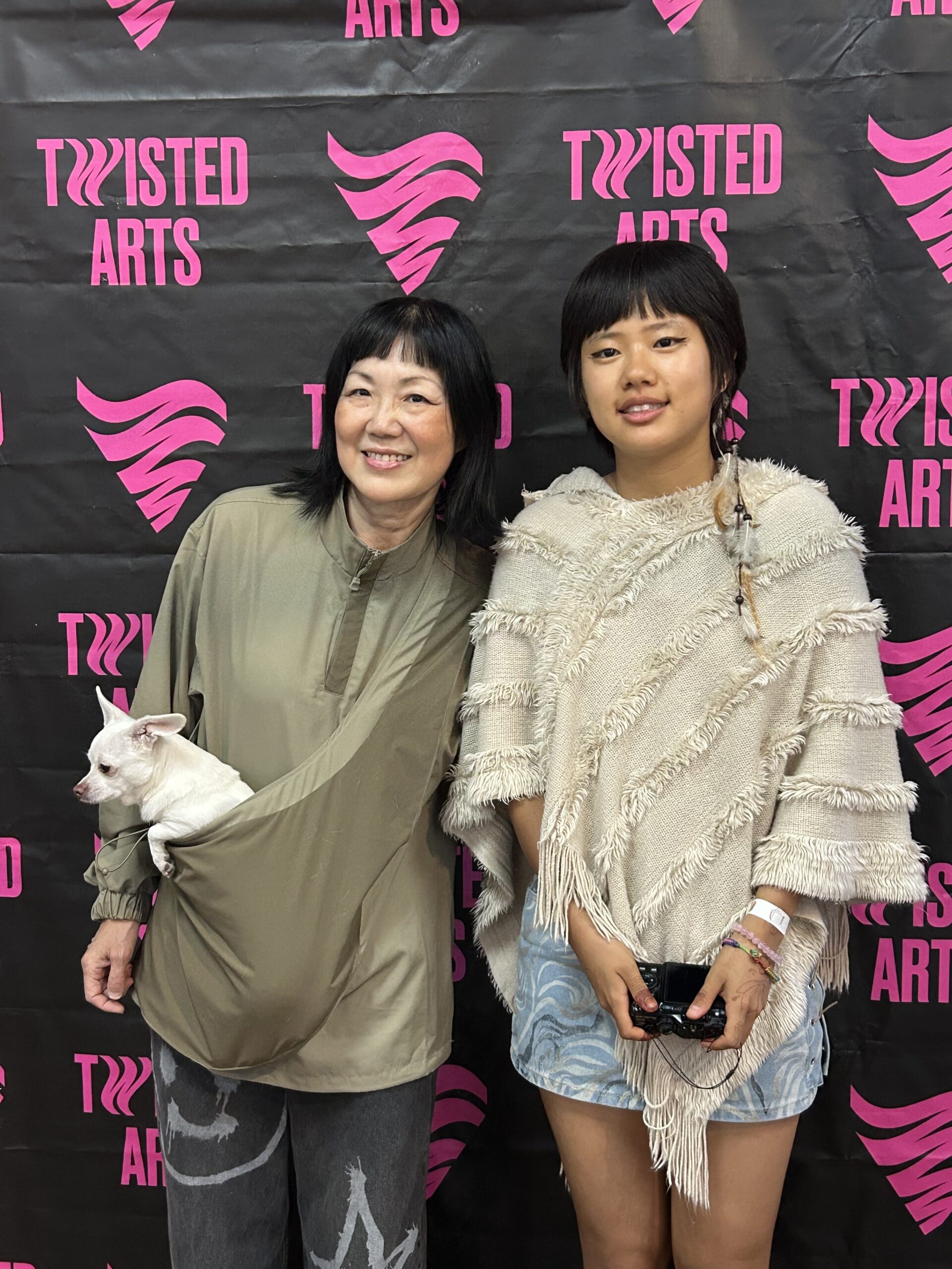 Chok Palmo and another person holding a a dog at an event.