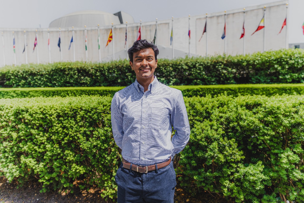 Matías Rodriguez standing in front of lush hedges.