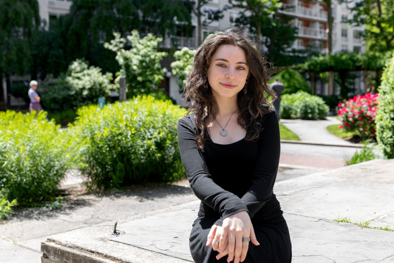 Shira Linsk sitting outside with greenery in the background.