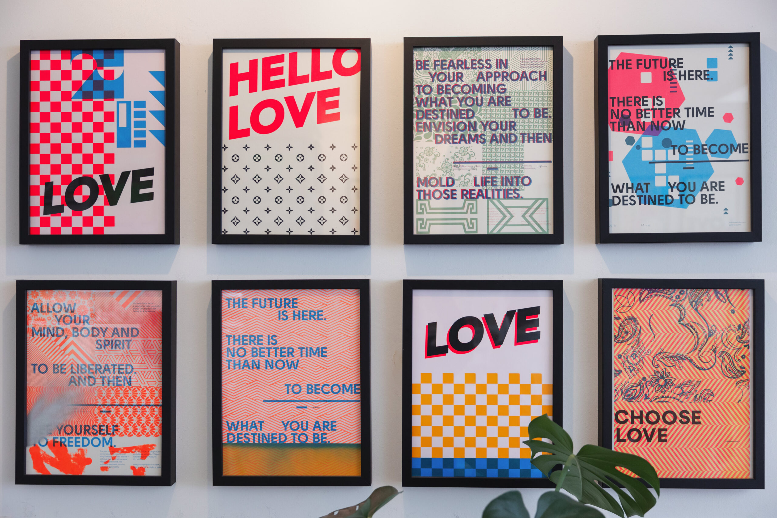 Framed HELLO LOVE posters cover a wall.