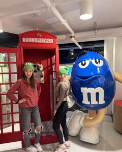 NYU London roommate pose for a photo in front of an iconic red telephone booth, representing our London study away experience.