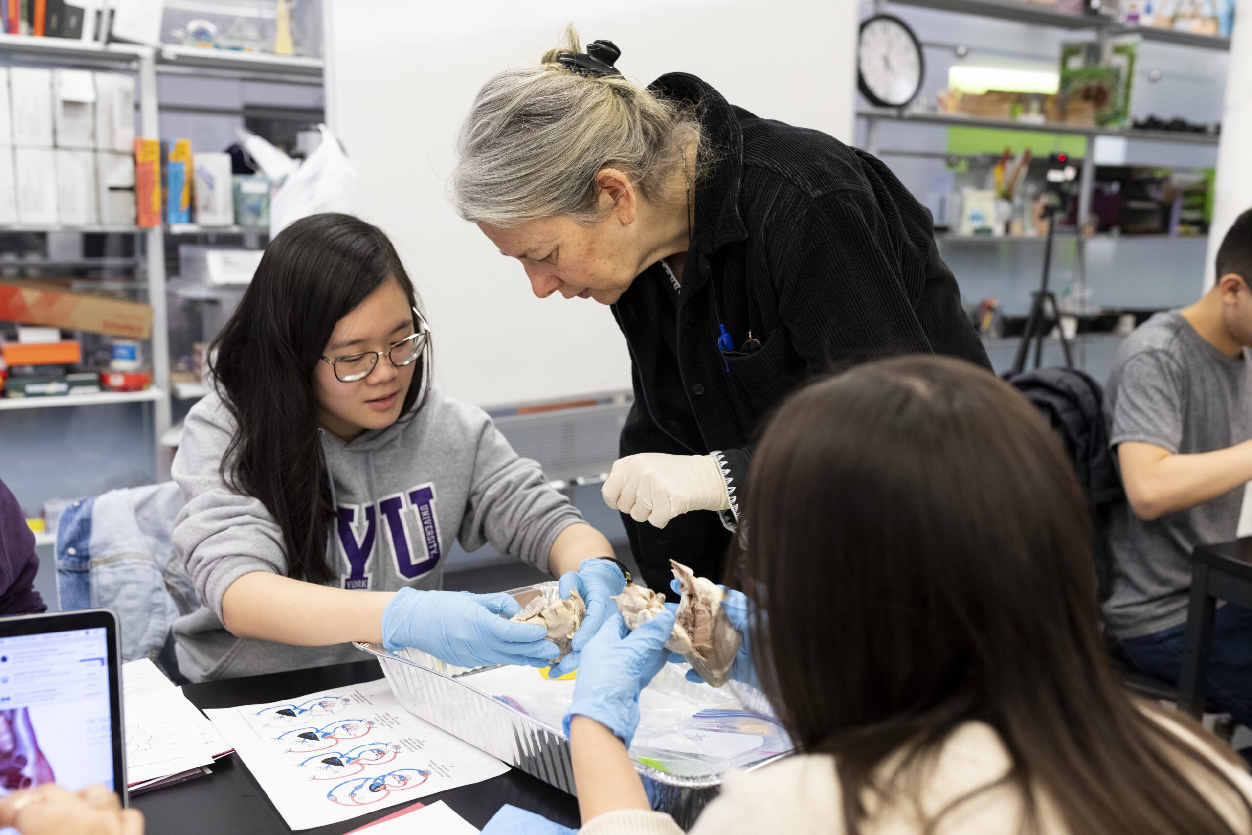 Students working with a professor in a lab.