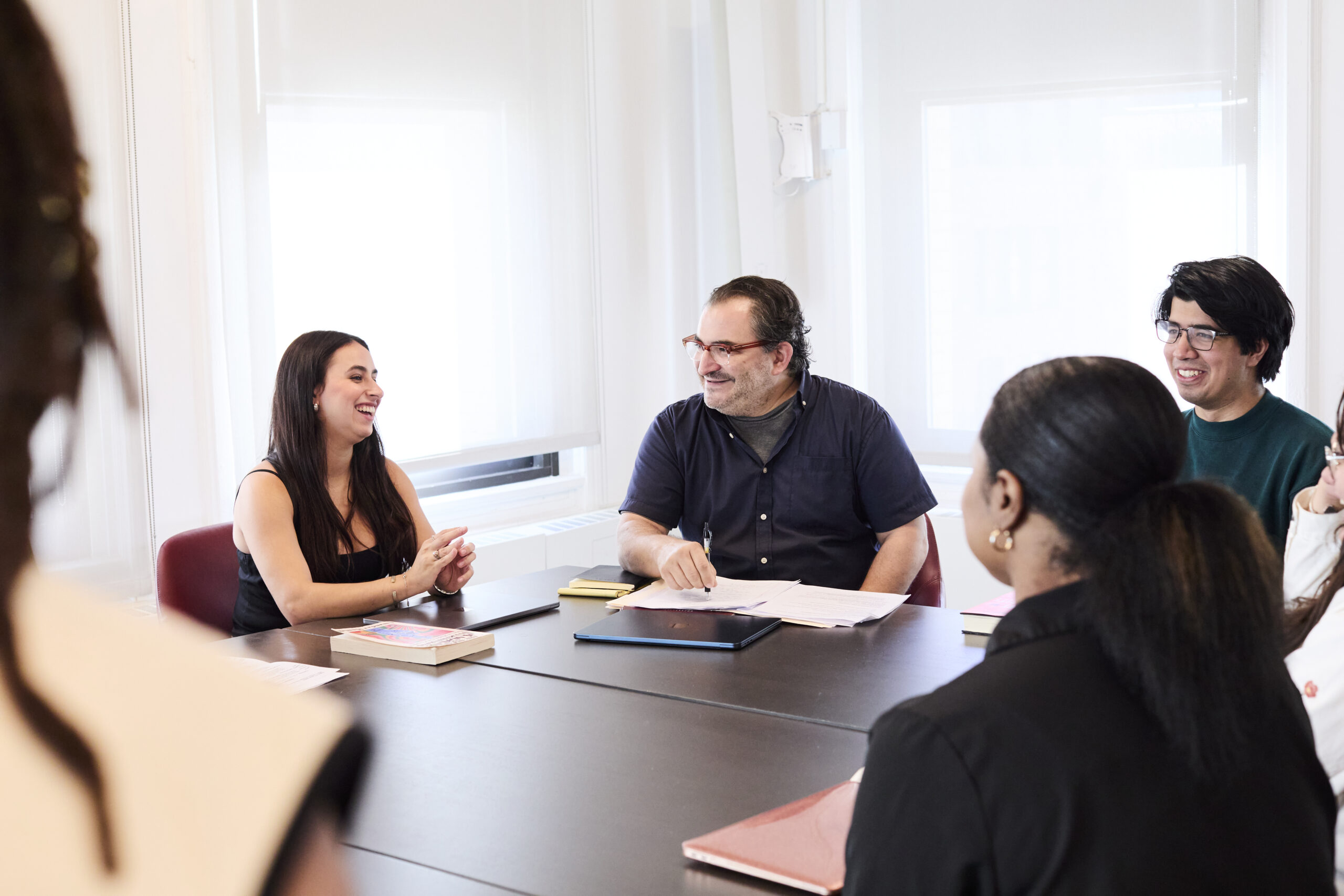 A group of students and a professor chat in class.