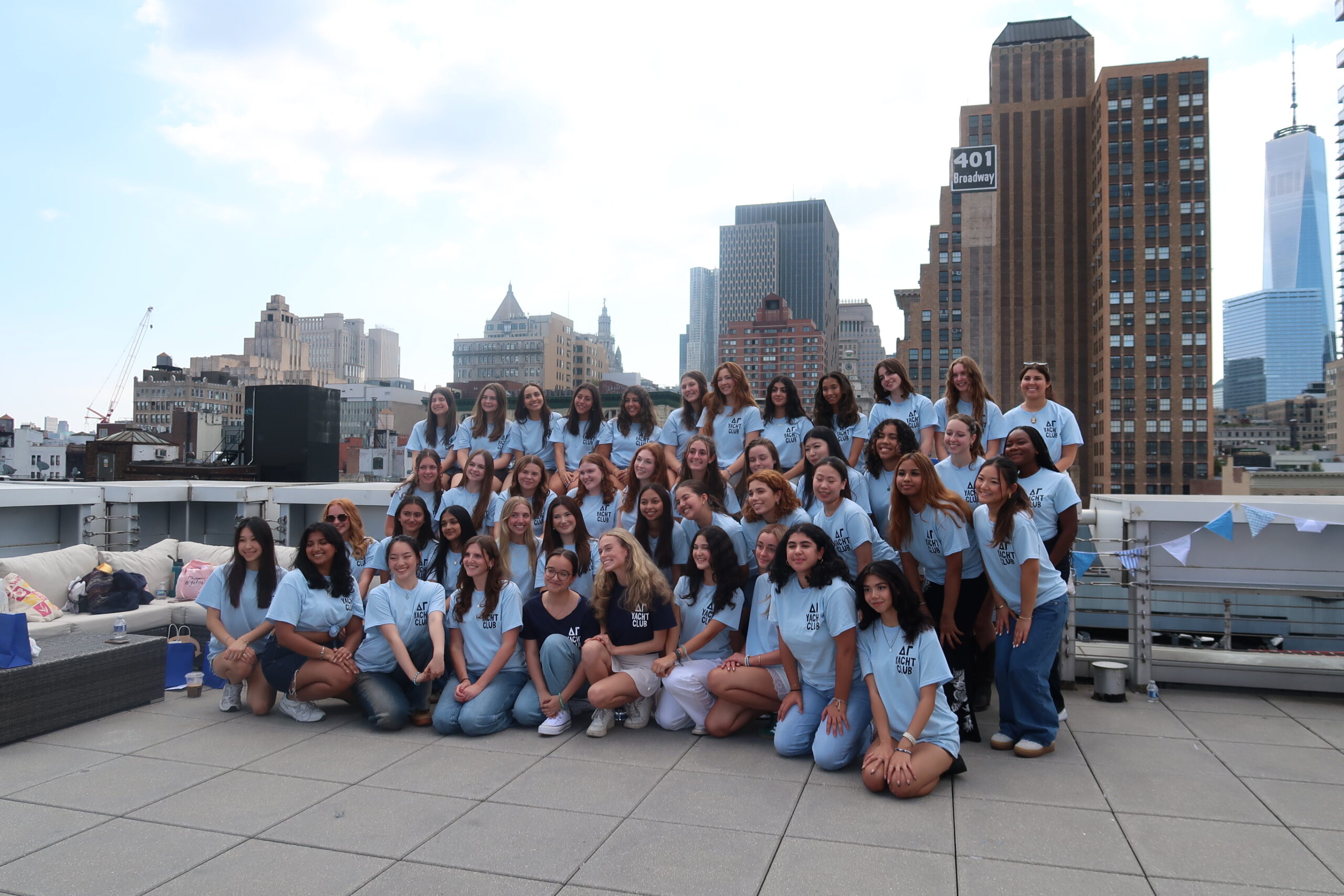 A large sorority group smiling and posed on a rooftop in New York City