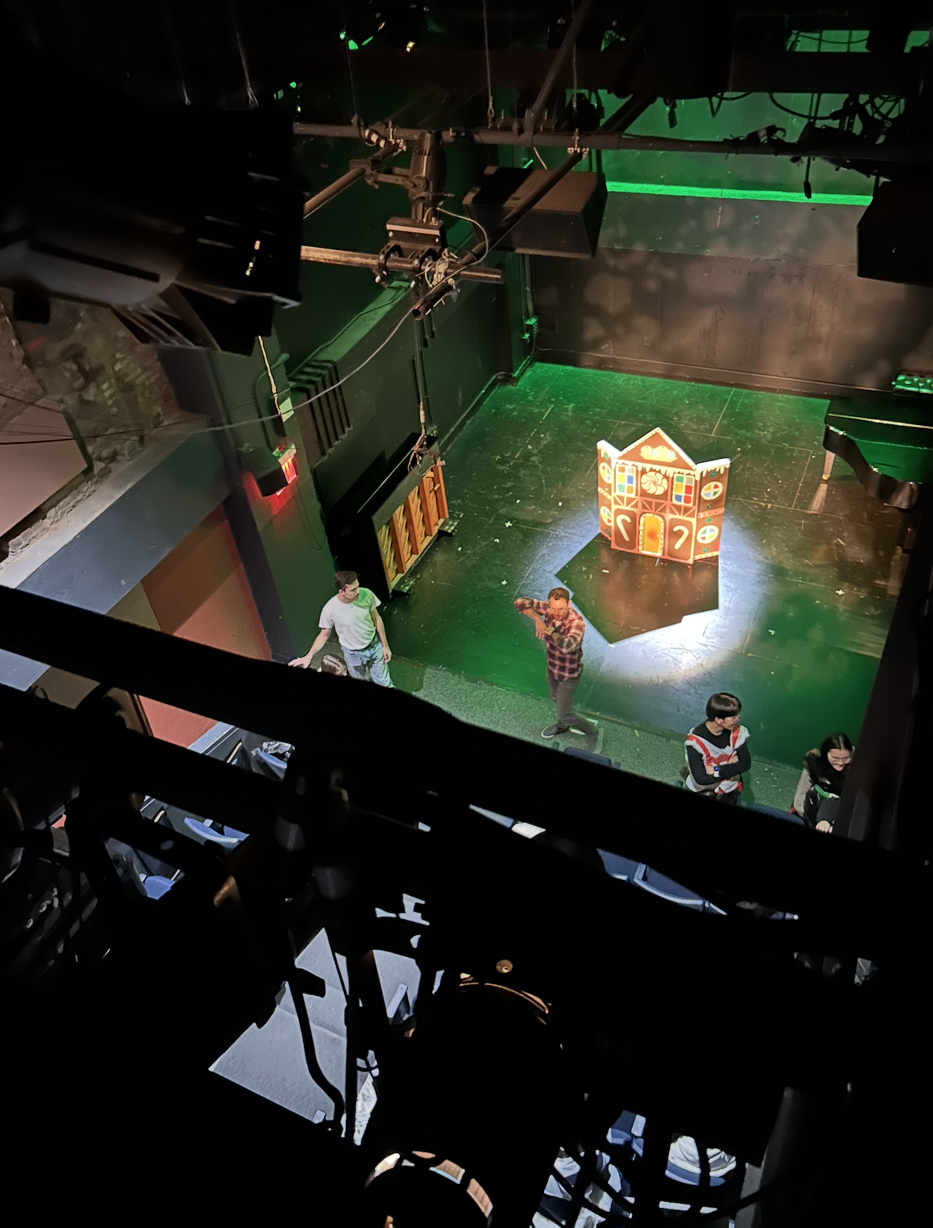 A gingerbread house centerstage with a light casting a big shadow.