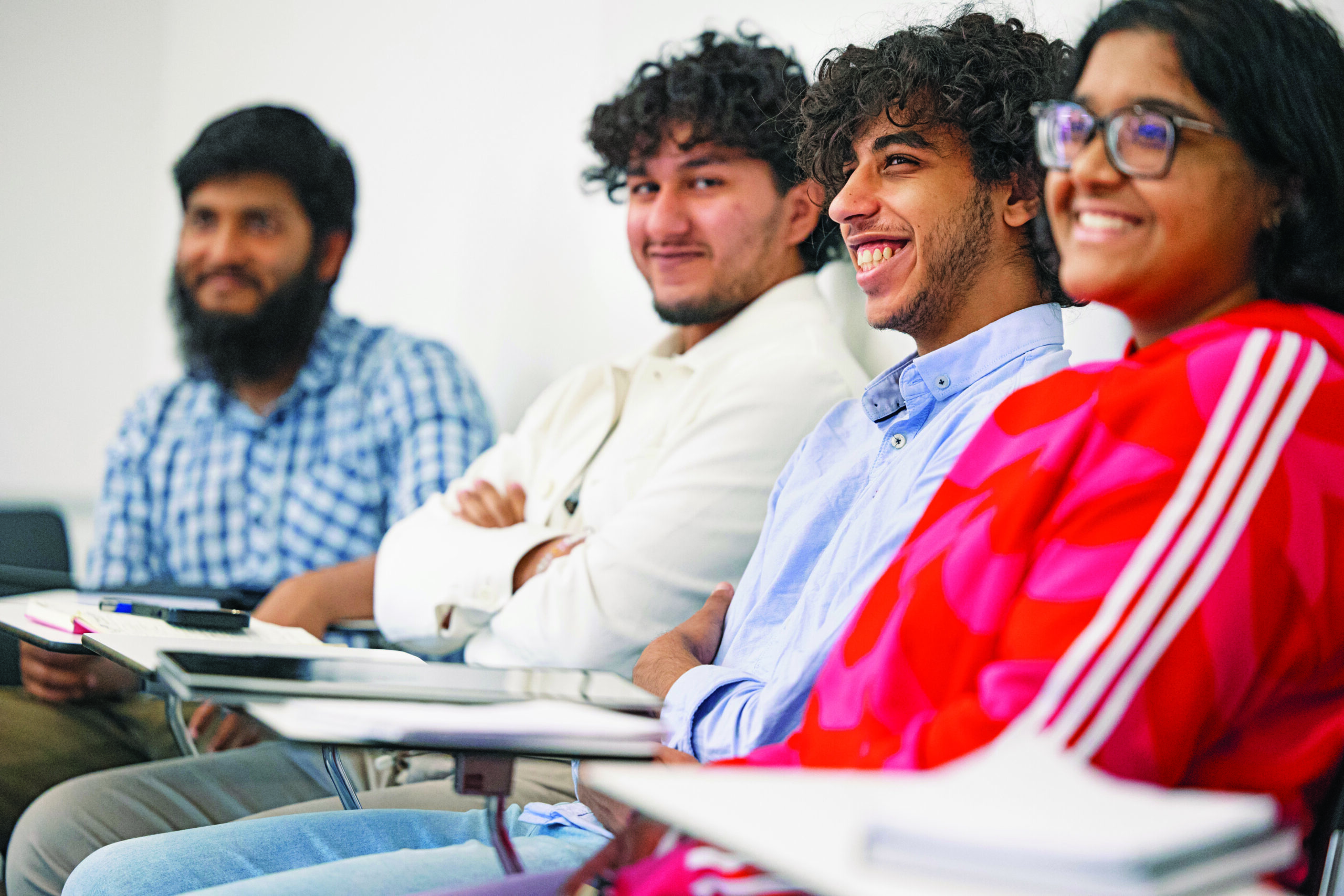 A group of students smiling in class.