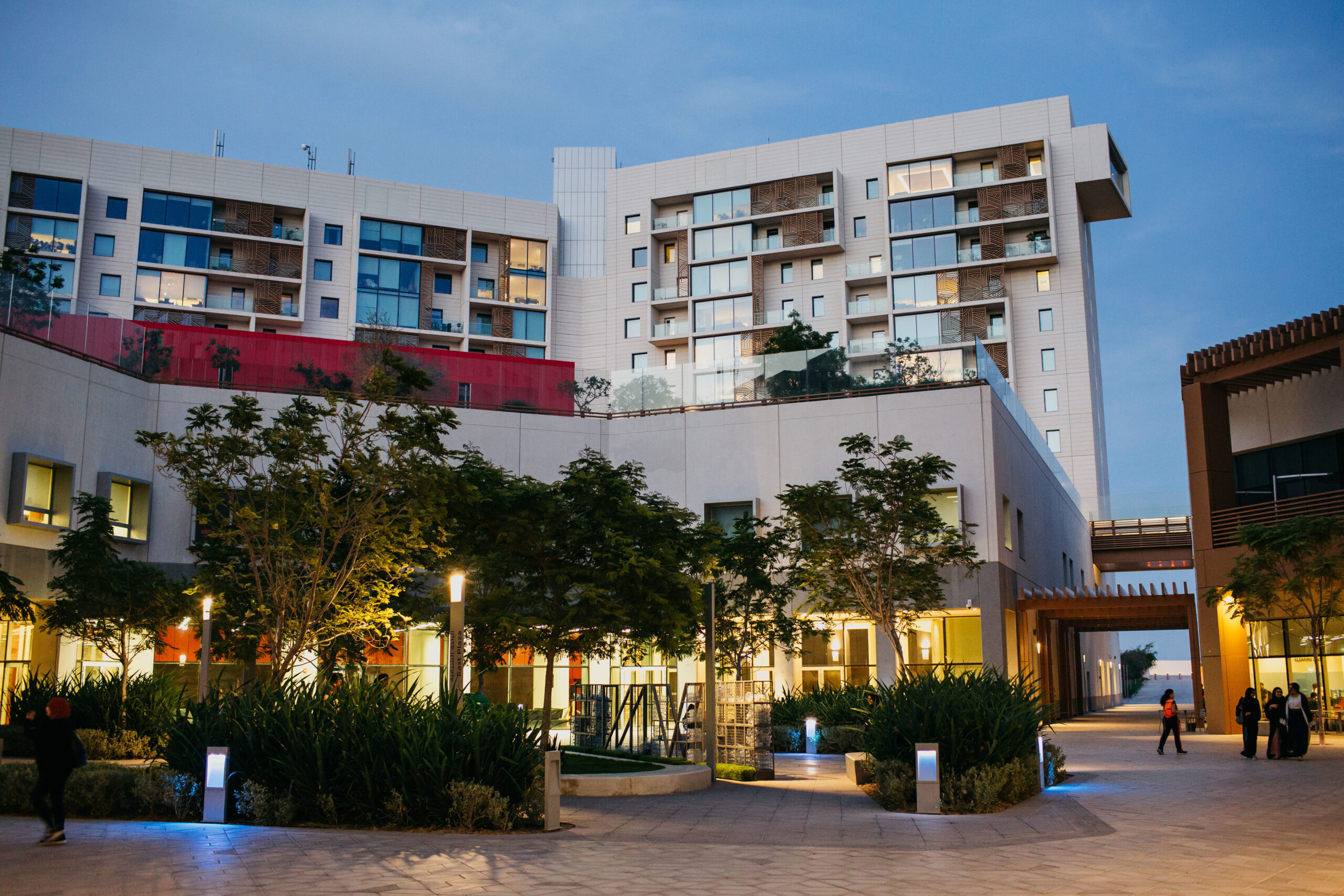 NYU Abu Dhabi campus buildings lit up at night.