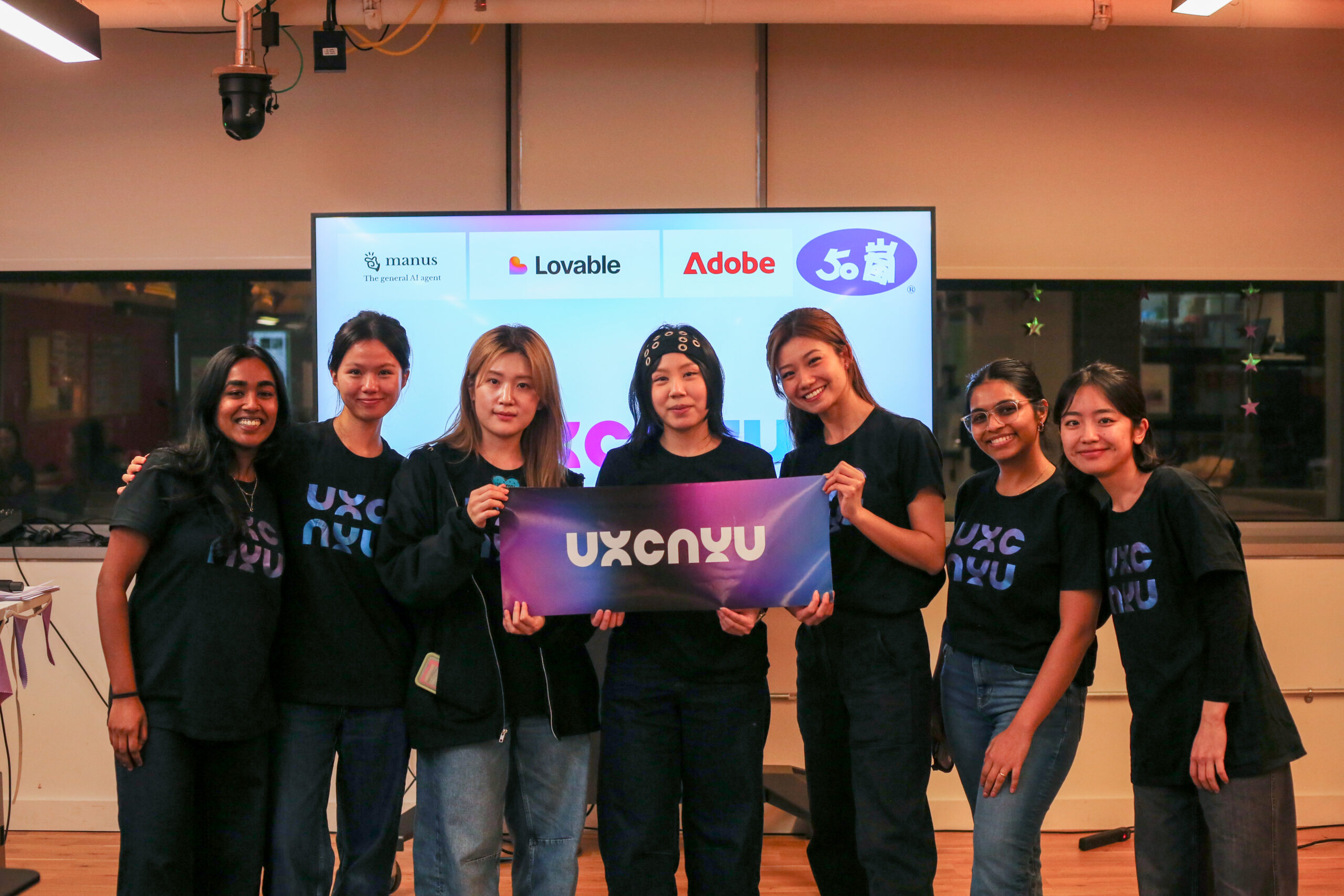 Members of the UX club hold up a banner that reads 