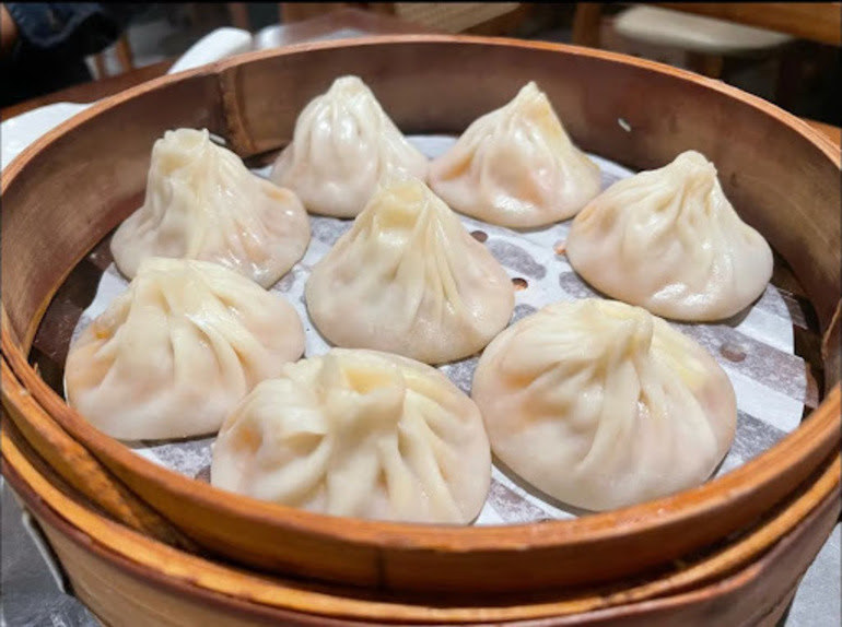 Steamed soup dumplings arranged in a bamboo basket.