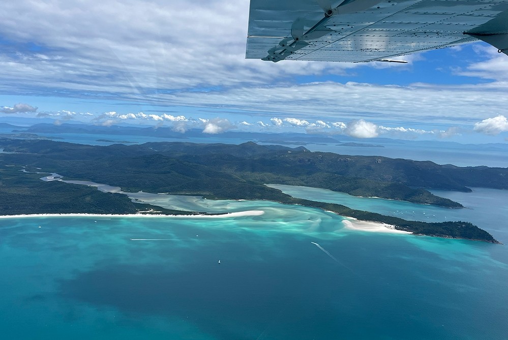 A bird's eye view of clear ocean and green islands.