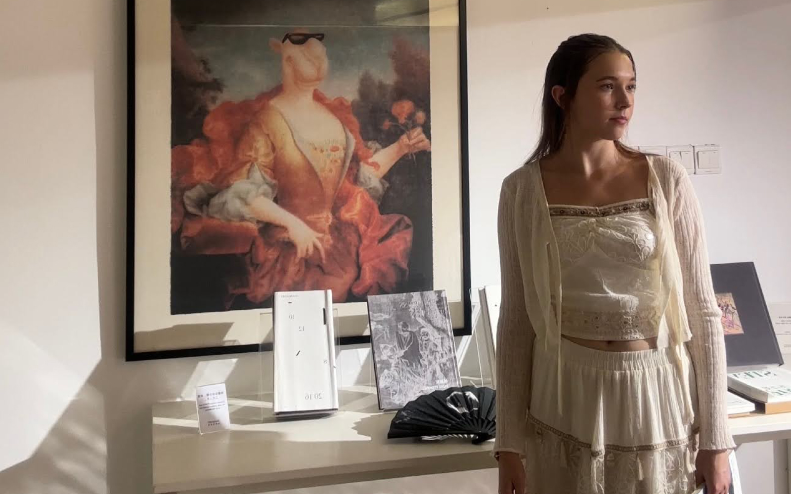 Masha Shramko standing in front of a framed artwork.