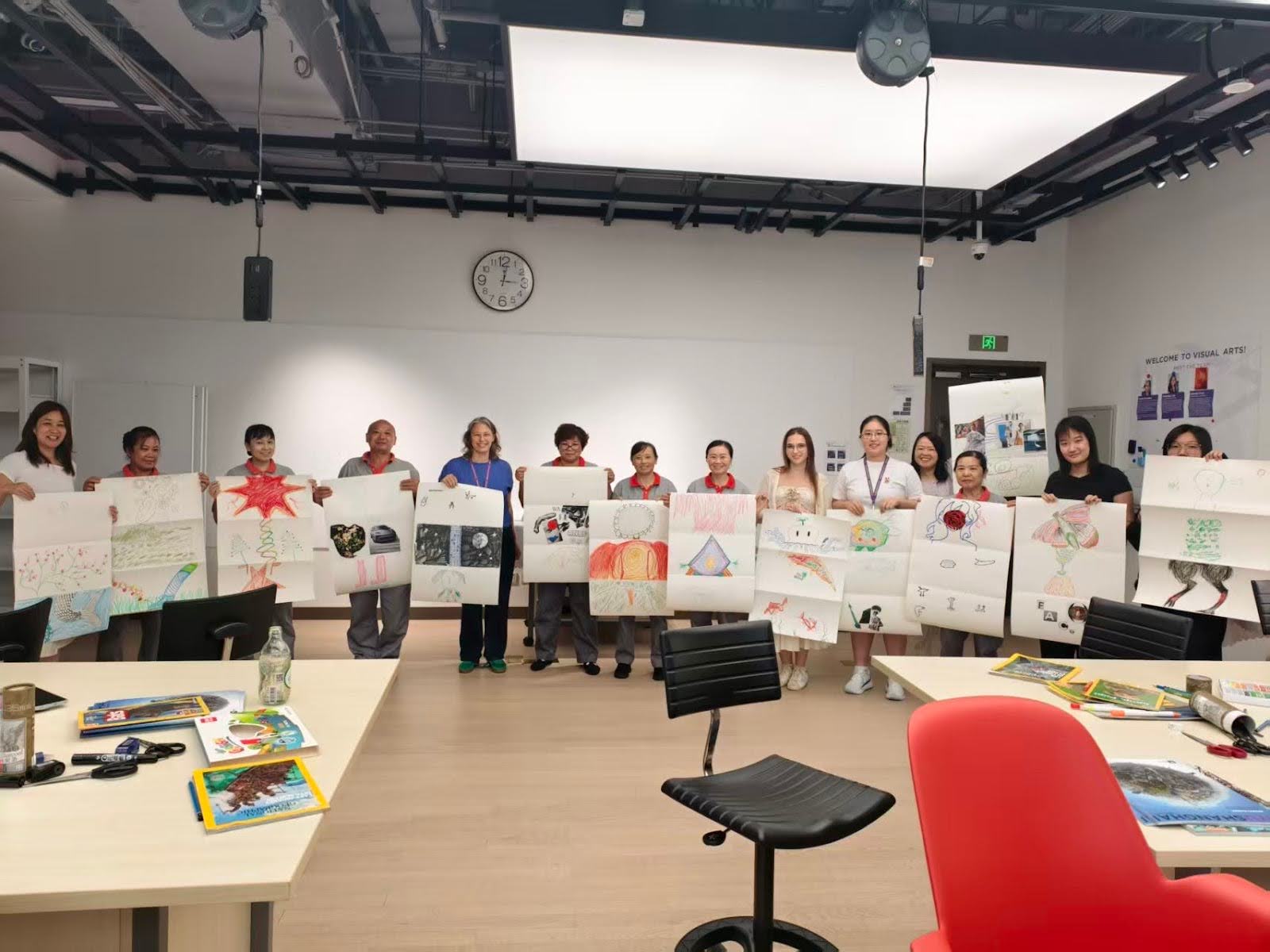 Students displaying their artwork created during a workshop where Masha volunteered.