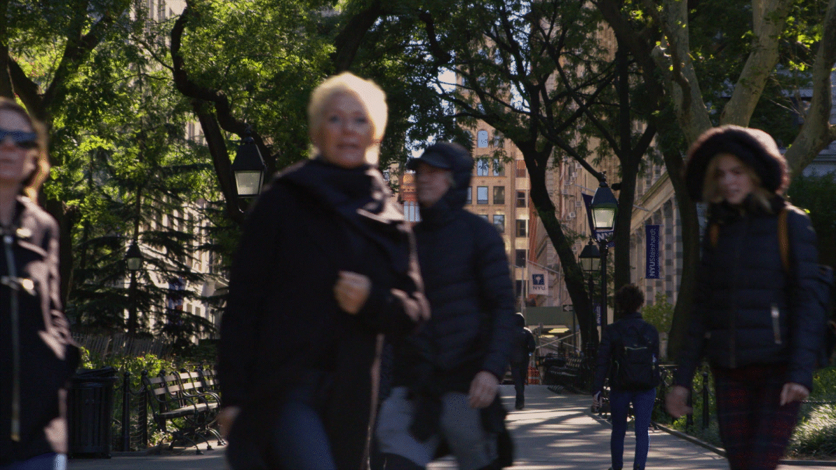 An animated gif of people walking through Washington Square Park on a windy autumn day.