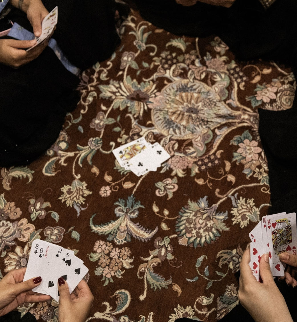 An overhead view of a group of people playing cards.