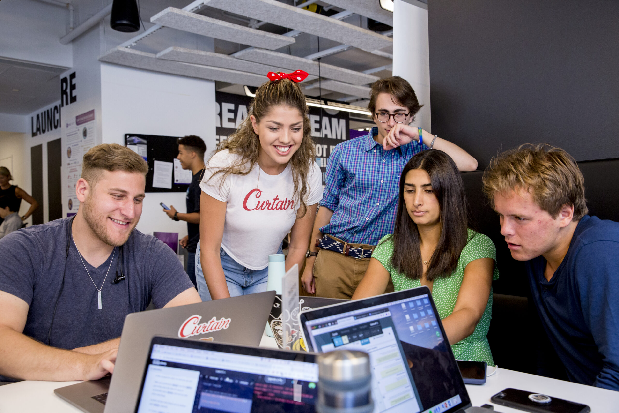 A group of students work on their laptops together.