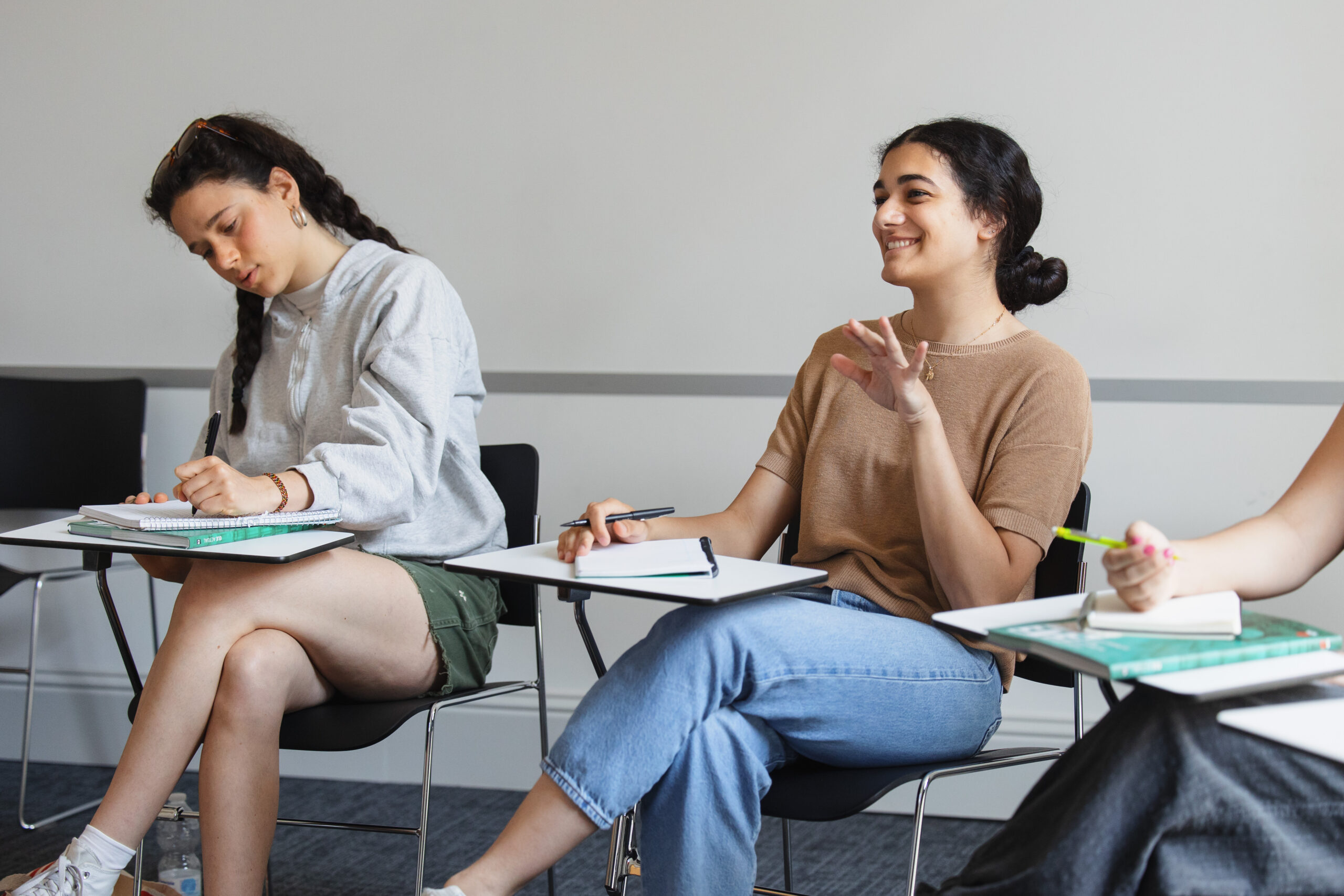 A student speaking enthusiastically in a classroom.