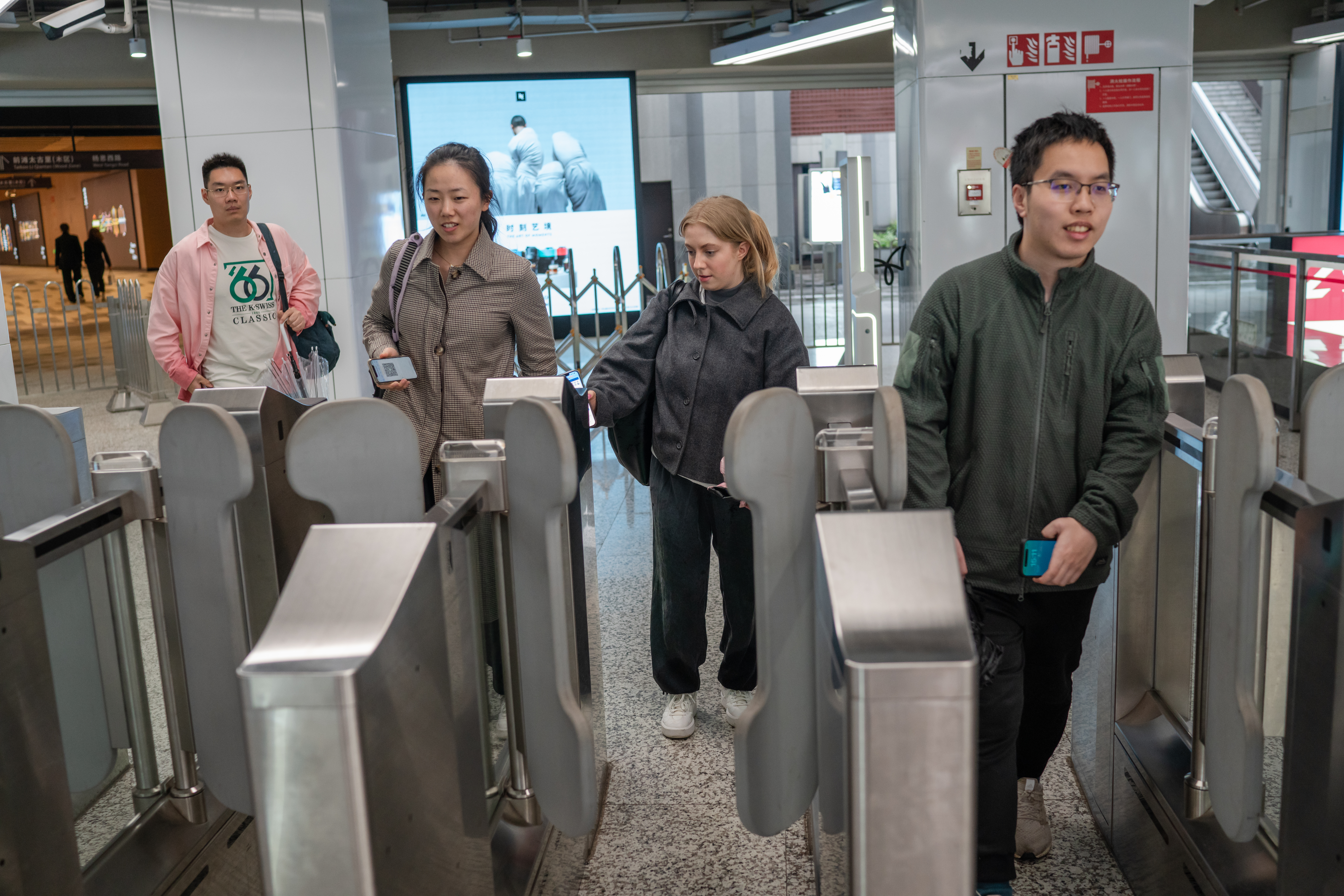Students paying their fare at a subway turnstile in Shanghai.