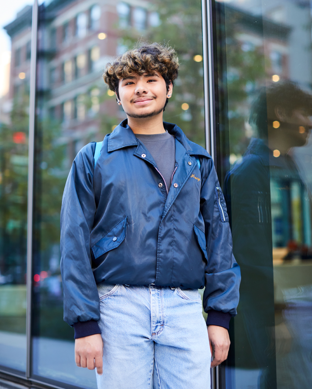 Edgar Pio Gracia standing in front of a building that is reflecting a city street.