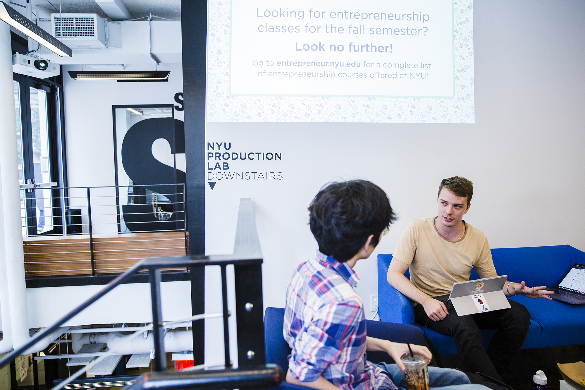 Two students have a discussion in a Leslie eLab lounge.