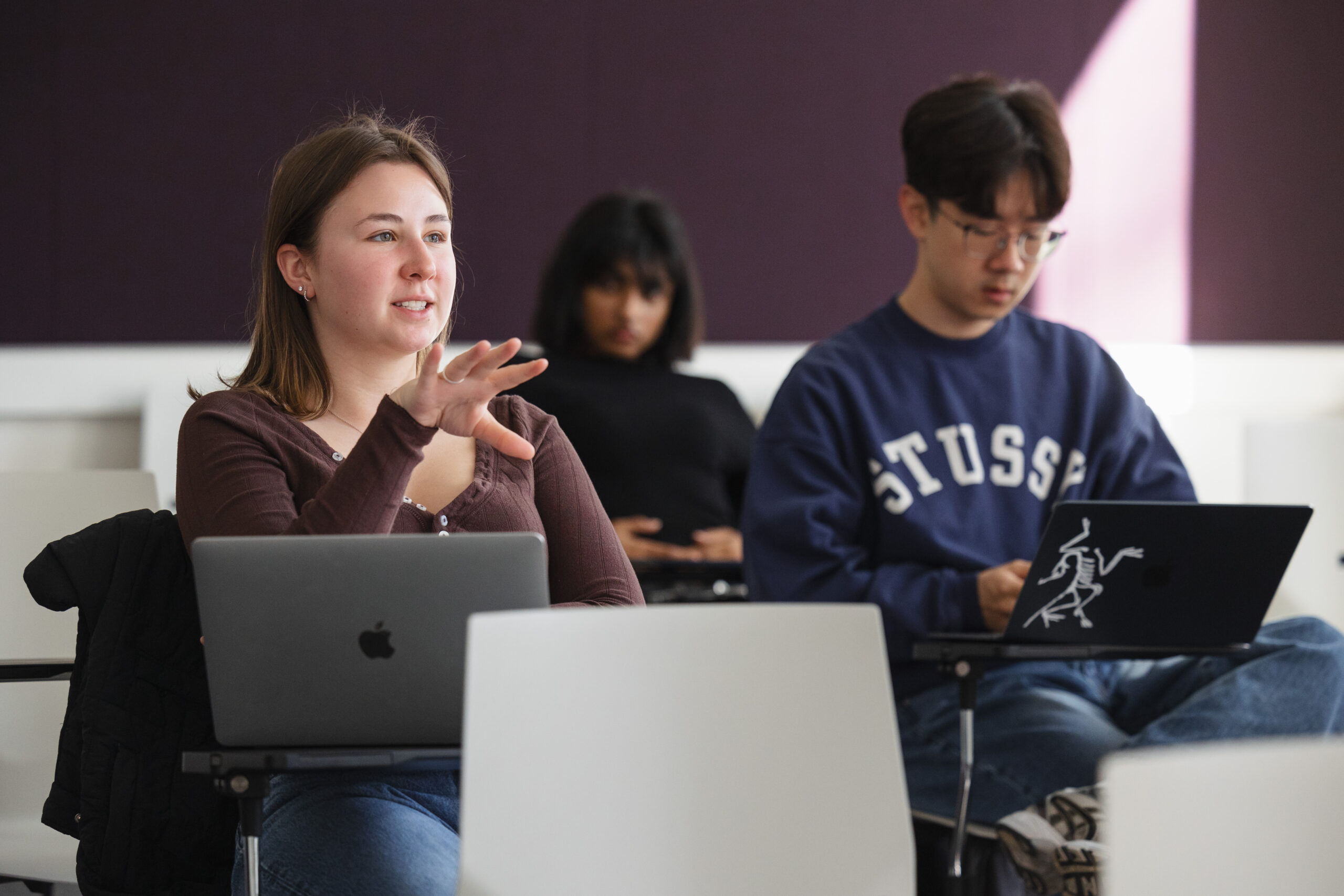 A group of students converse in class.