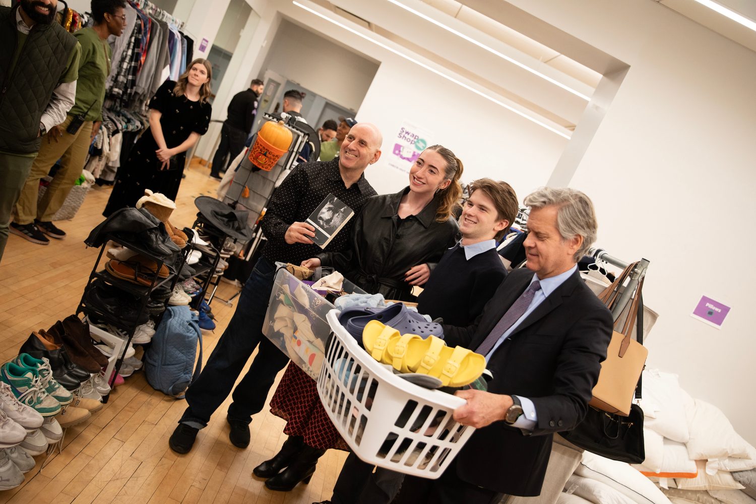 A group of people holding goods from the Swap Shop.