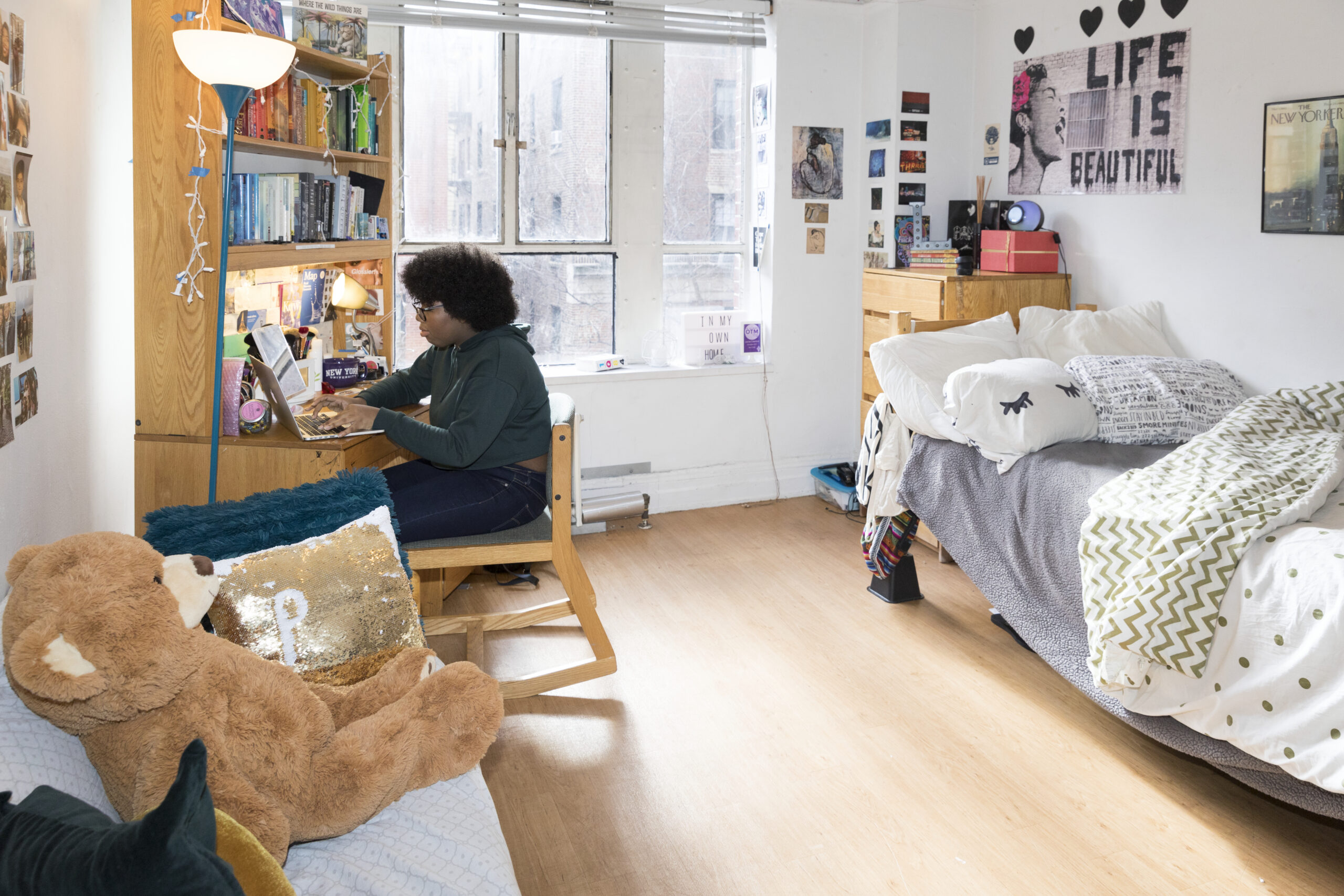 A student studying in their decorated dorm room.