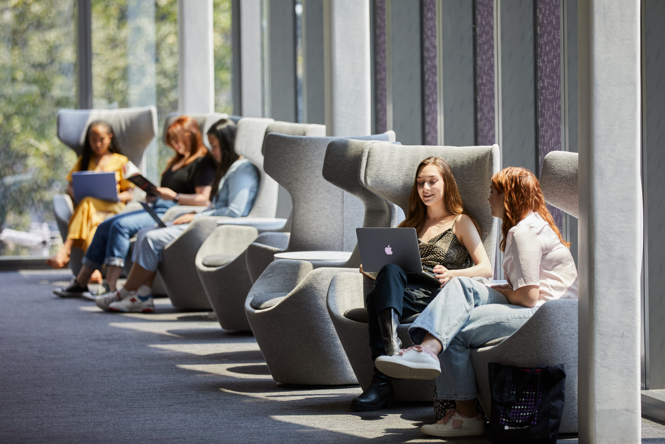 Students hanging out in a bright, sunny lounge area.
