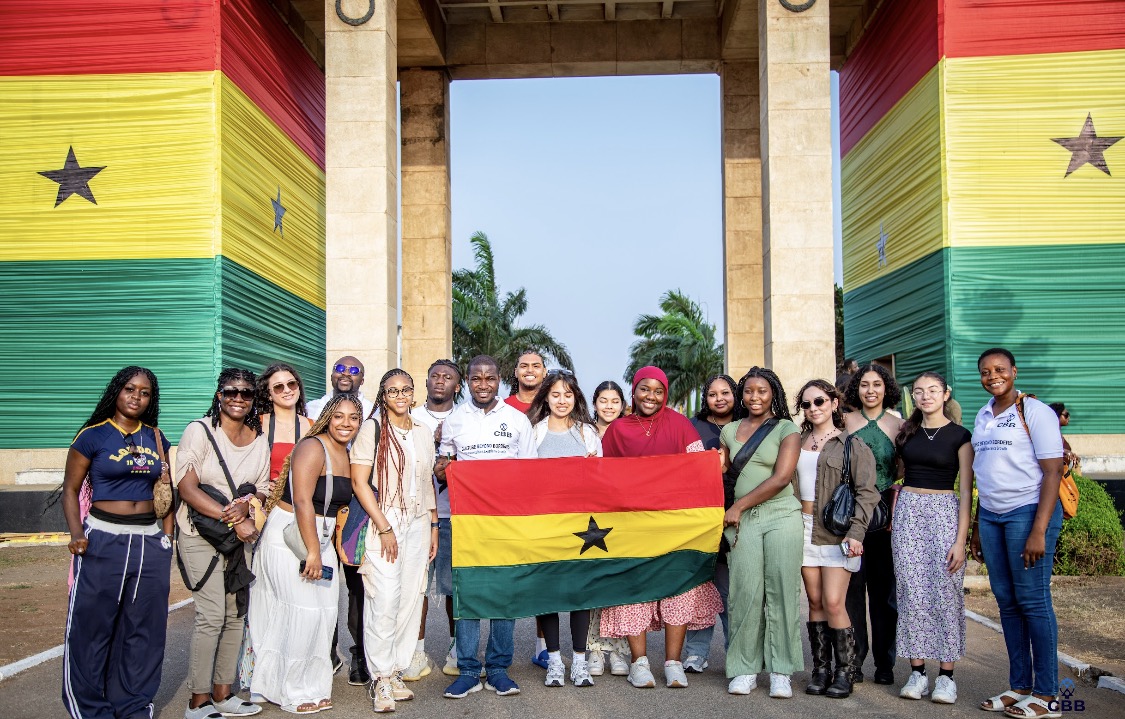 A group of students holding the Ghanaian flag.