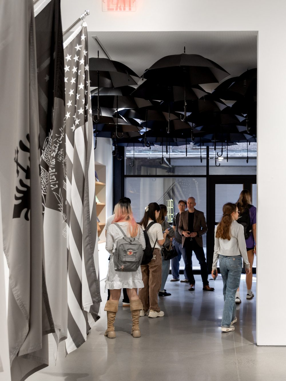 A group of people walking around an art gallery.