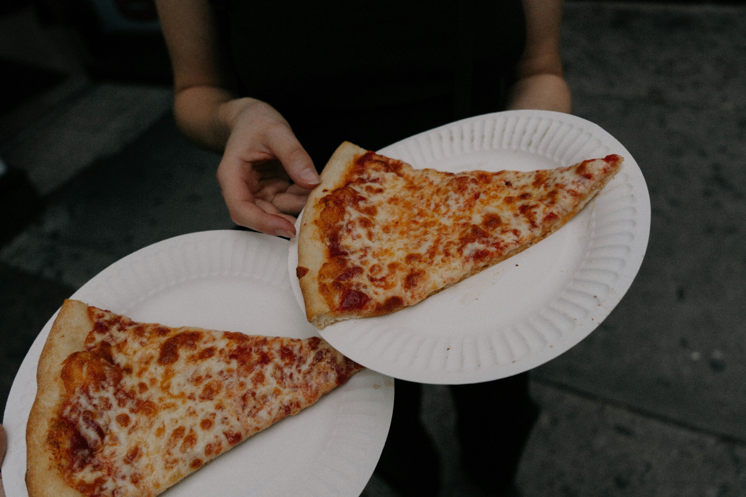 Two slices of pizza on plates.