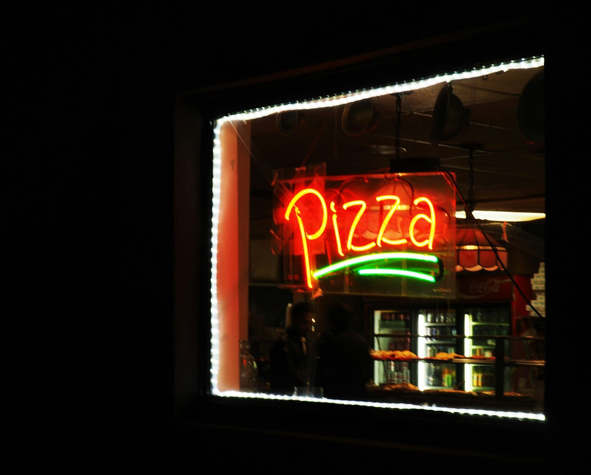 A neon sign in a window that reads 