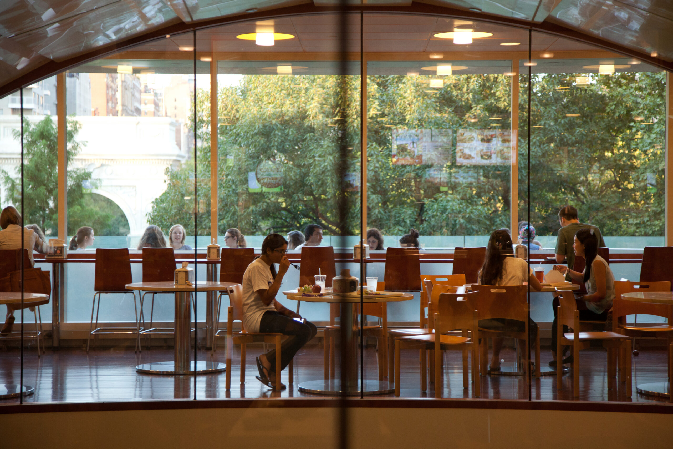 Students eat a meal in a spacious cafeteria.
