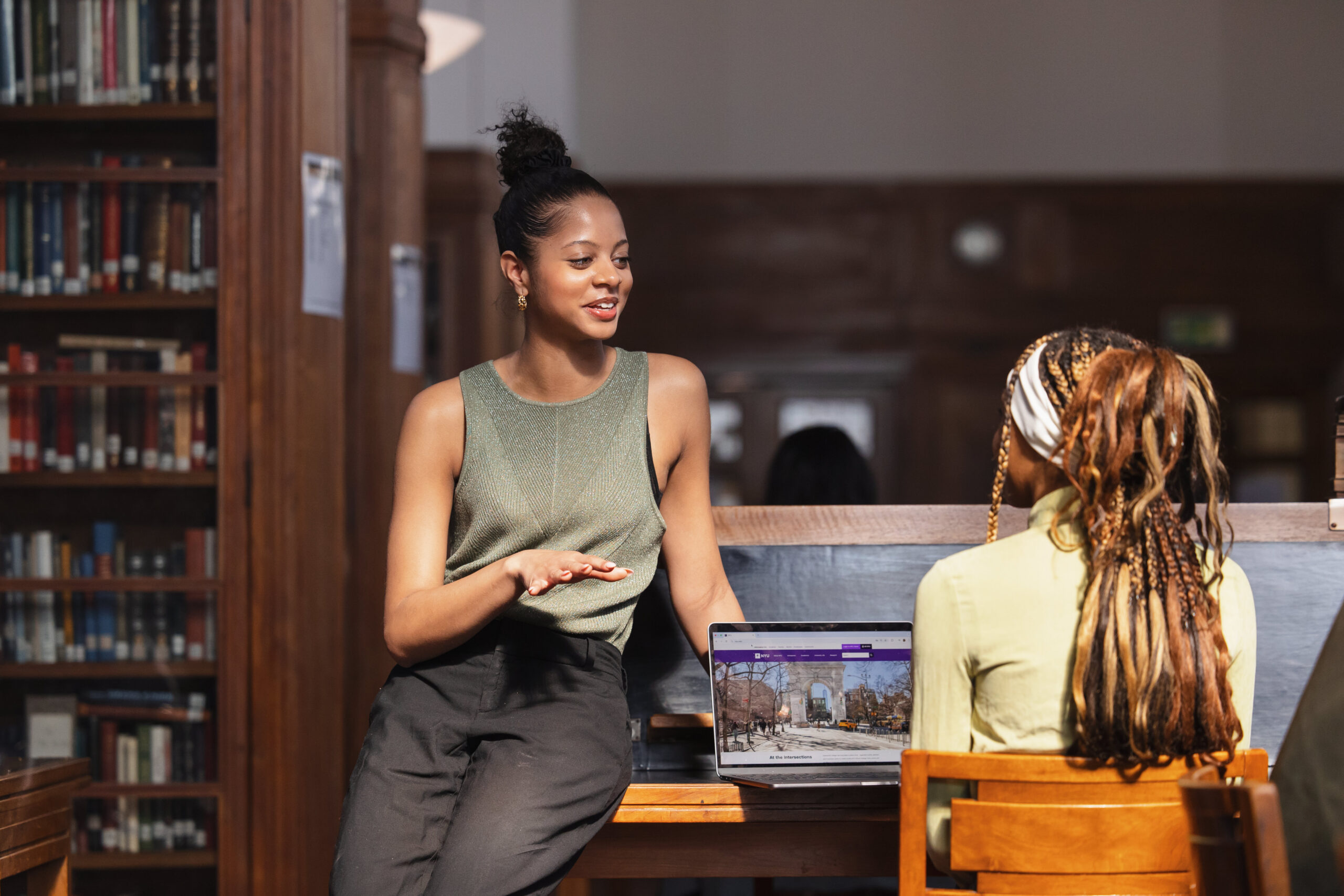 Two students talking in a library