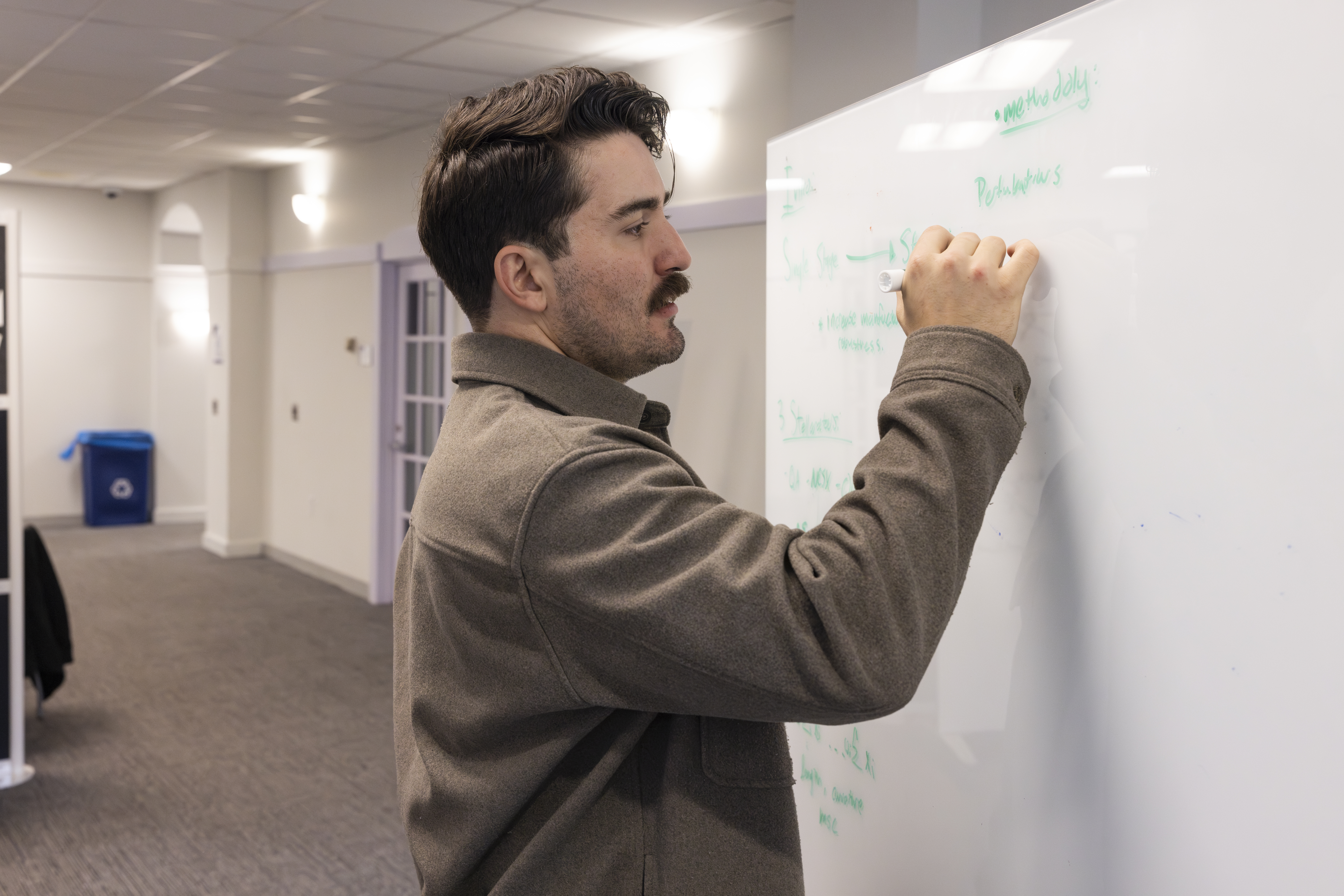 Vinnie Gallegos taking notes on a whiteboard.