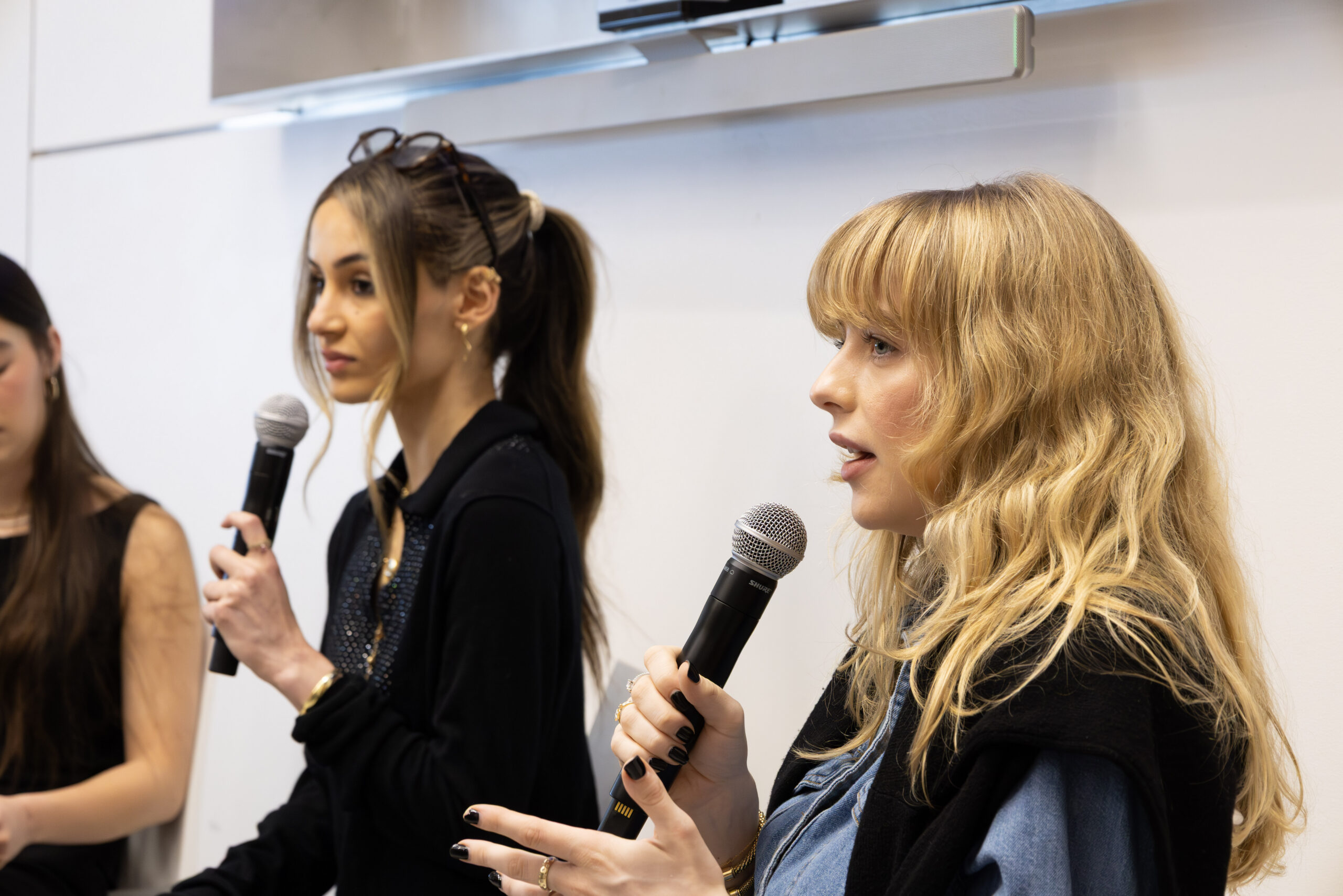 Two people speaking into microphones during a panel discussion.