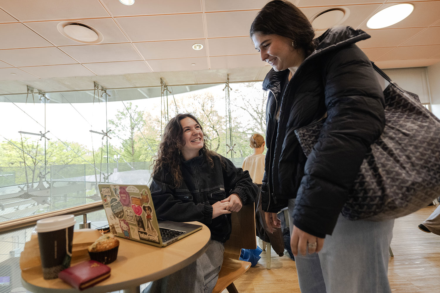 Two students talking in Peet’s Coffee inside the Kimmel Center.